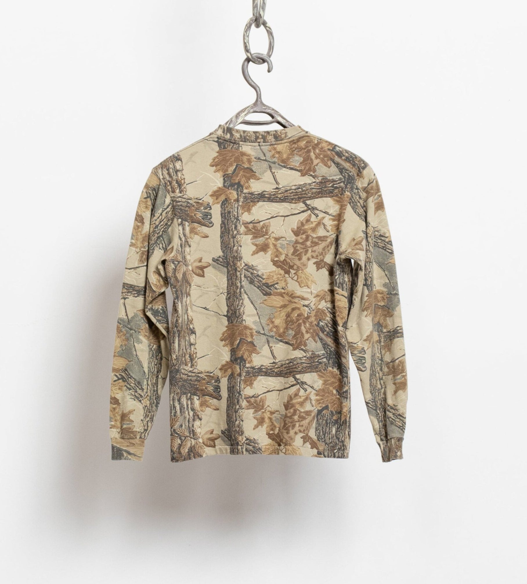 Camouflage-patterned shirt on a hanger against a white background
