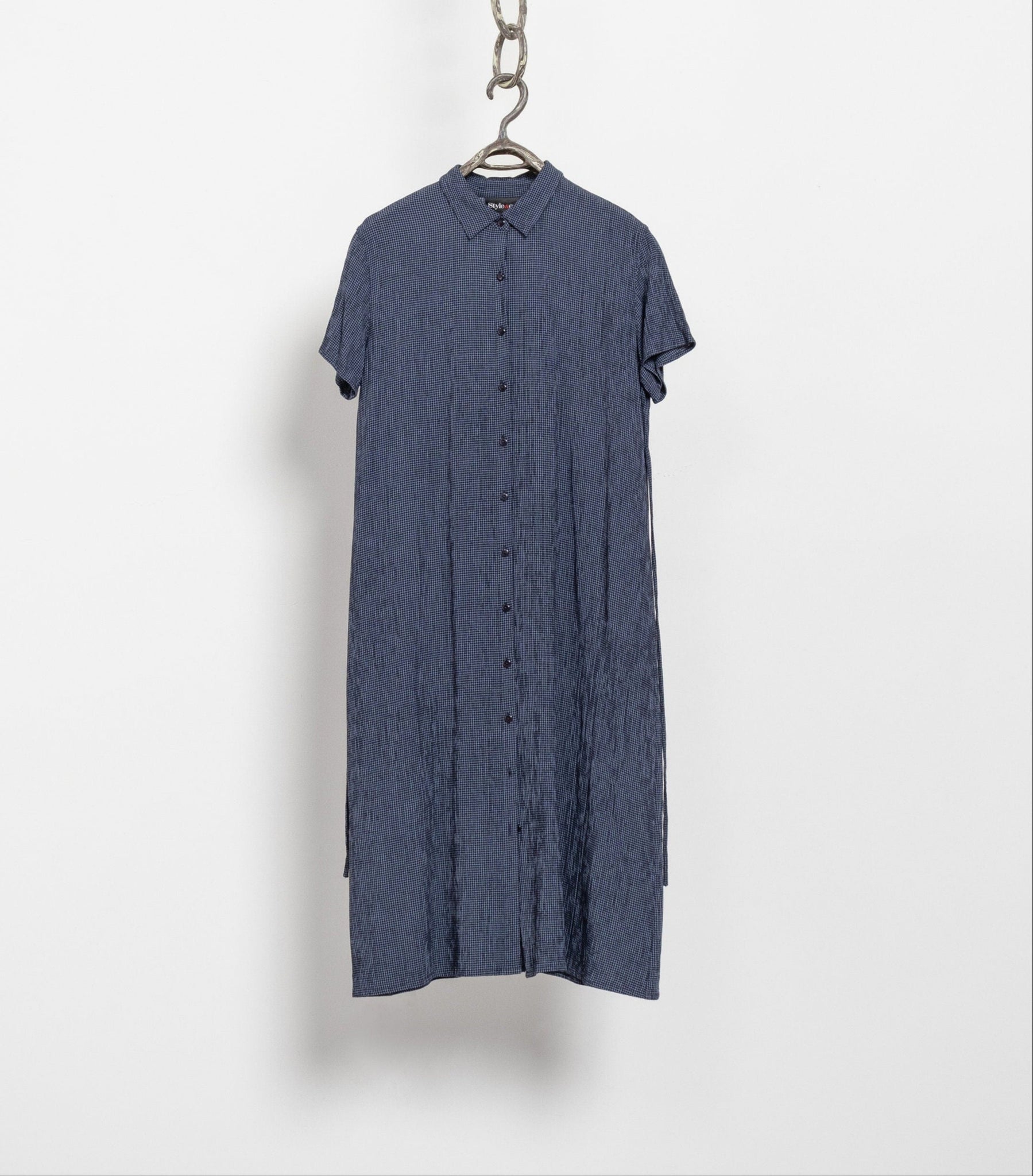 A navy blue and white crinkle textured vintage maxi dress with short sleeves, hanging on a chain against a white background.