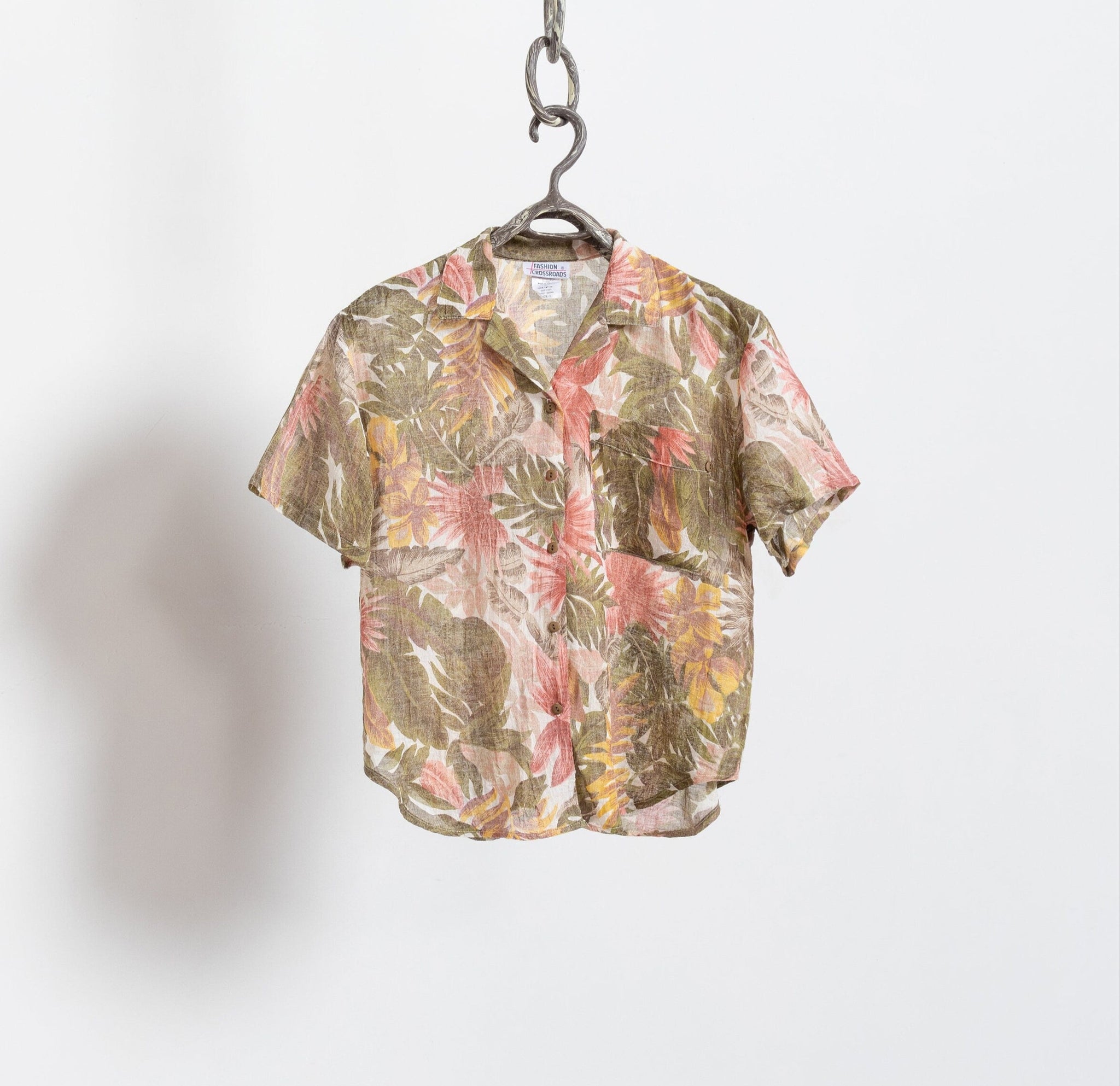 Floral patterned shirt on a hanger against a white background