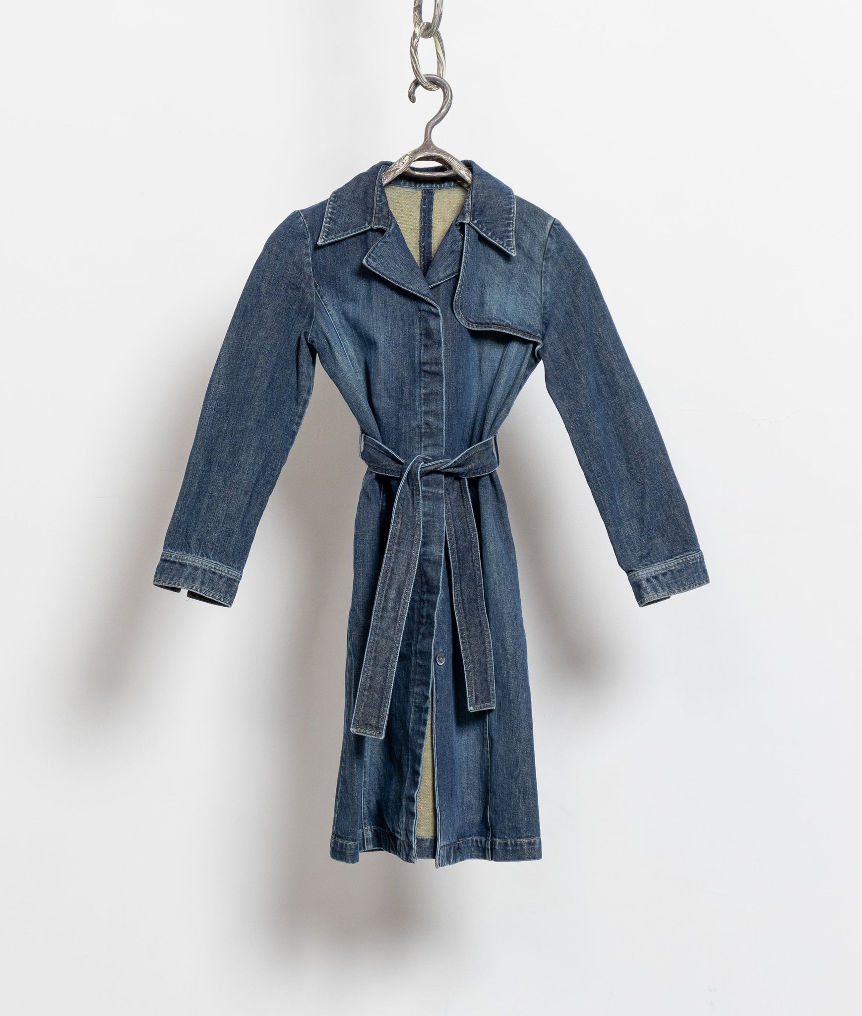 Blue denim coat on a hanger against a white background