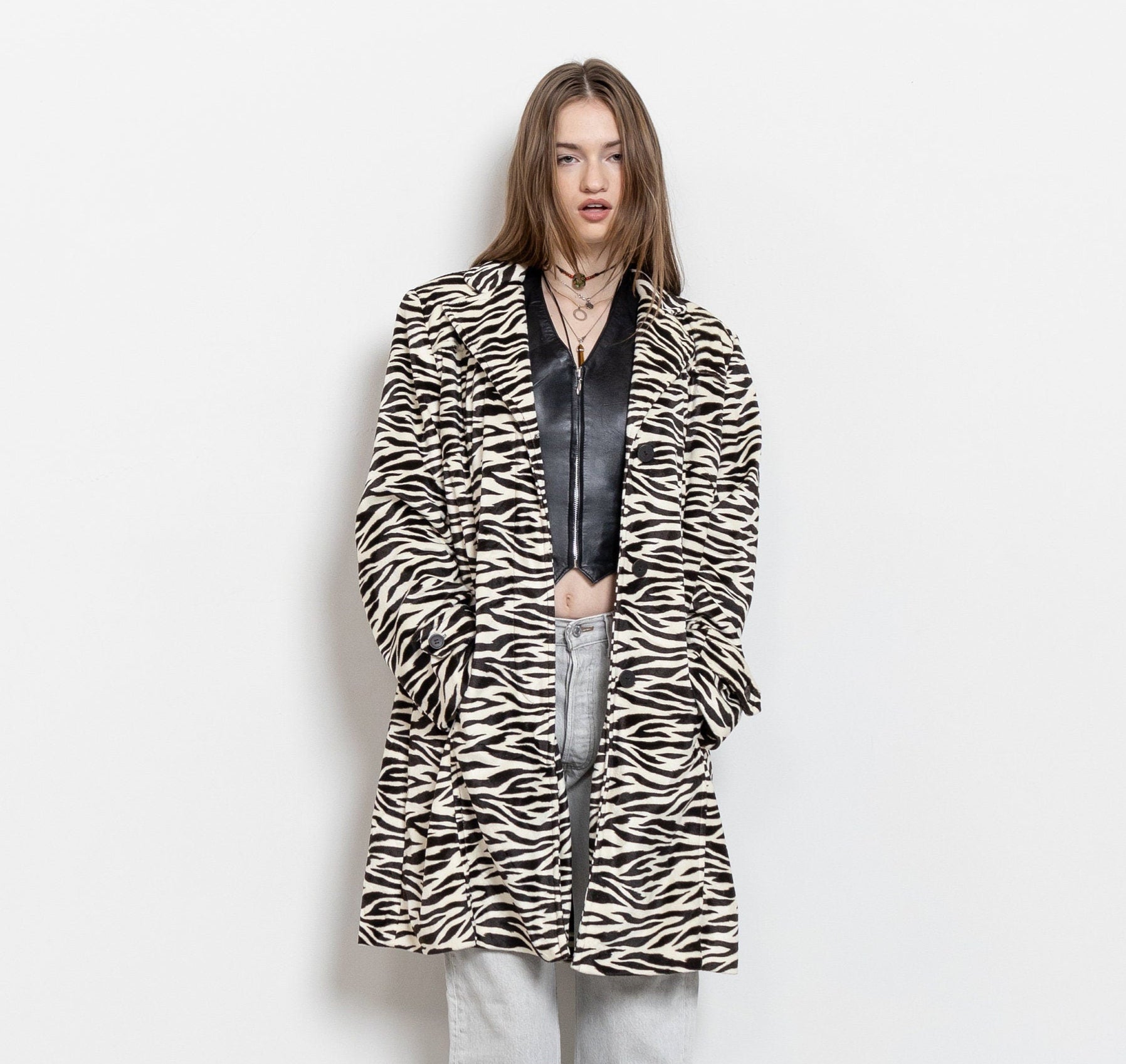 Person wearing a zebra print coat on a white background