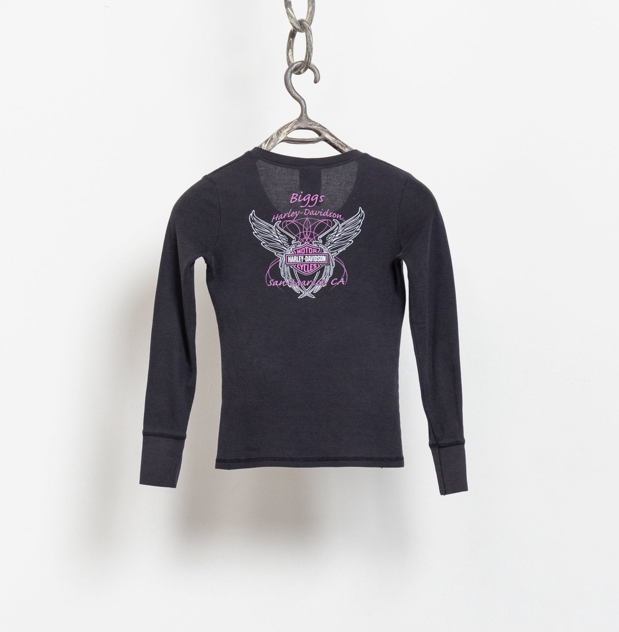 A Harley Davidson logo baby tee in black with vintage graphics, displayed on a hanger against a white background.