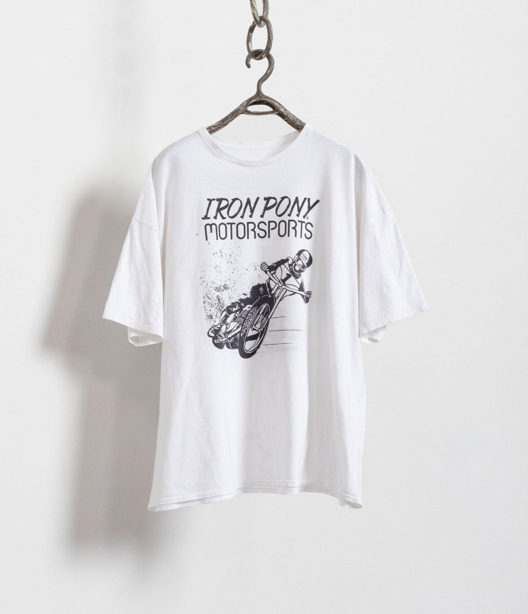 White t-shirt with 'Iron Pony Motorsports' graphic on a hanger against a white background