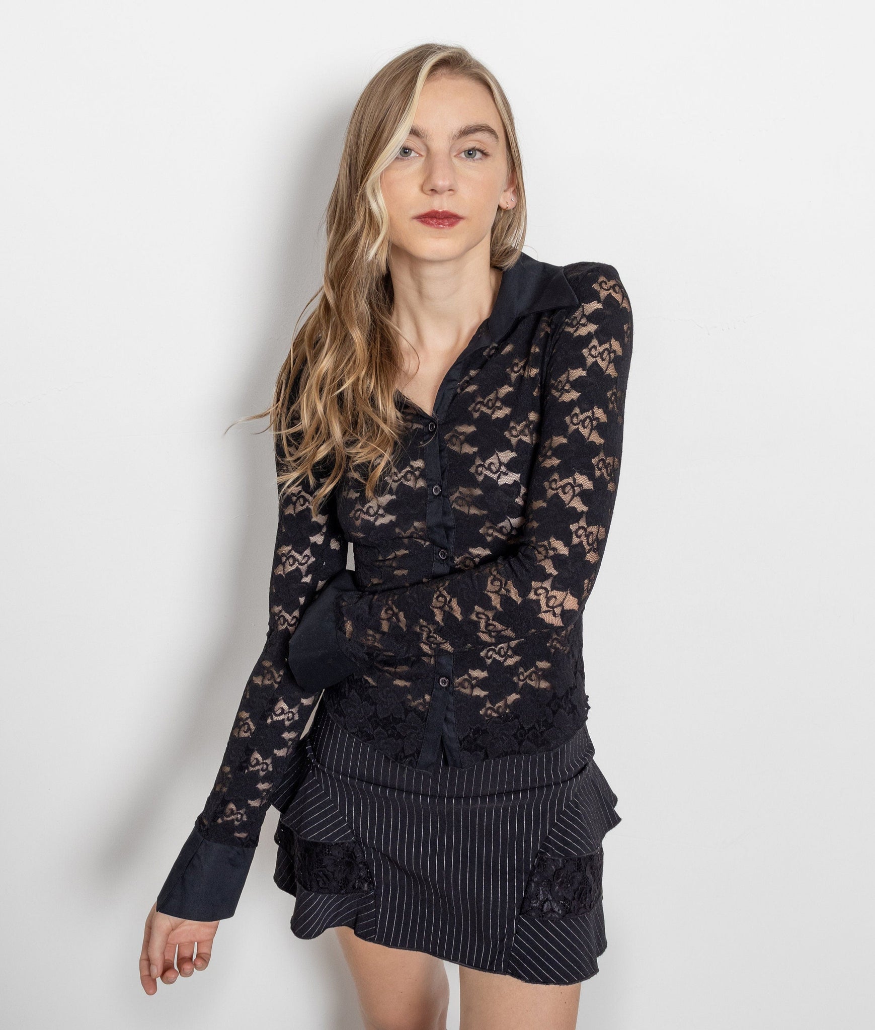 Woman wearing a black lace outfit against a white background