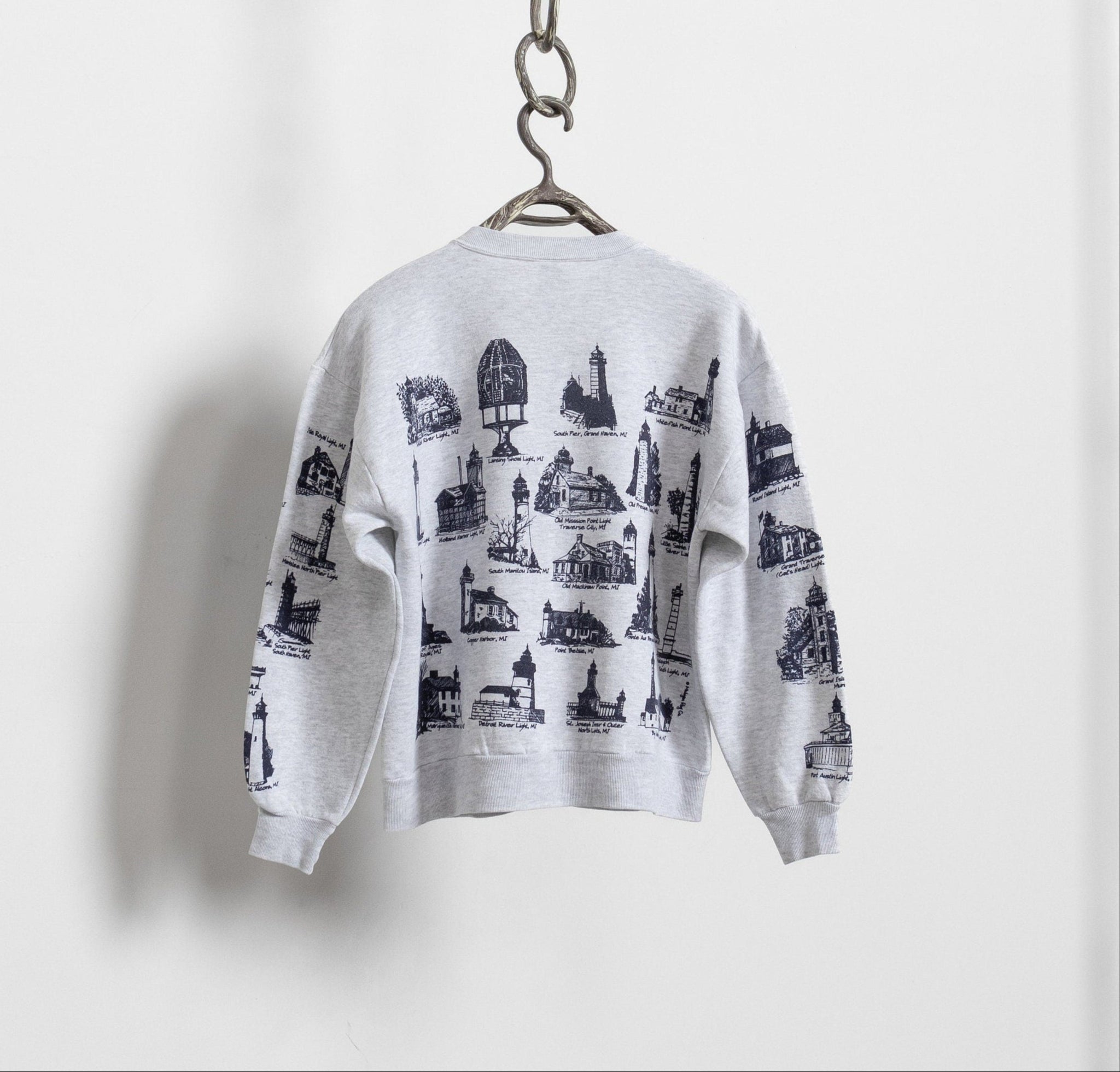White sweatshirt with black graphic design on a hanger against a white background