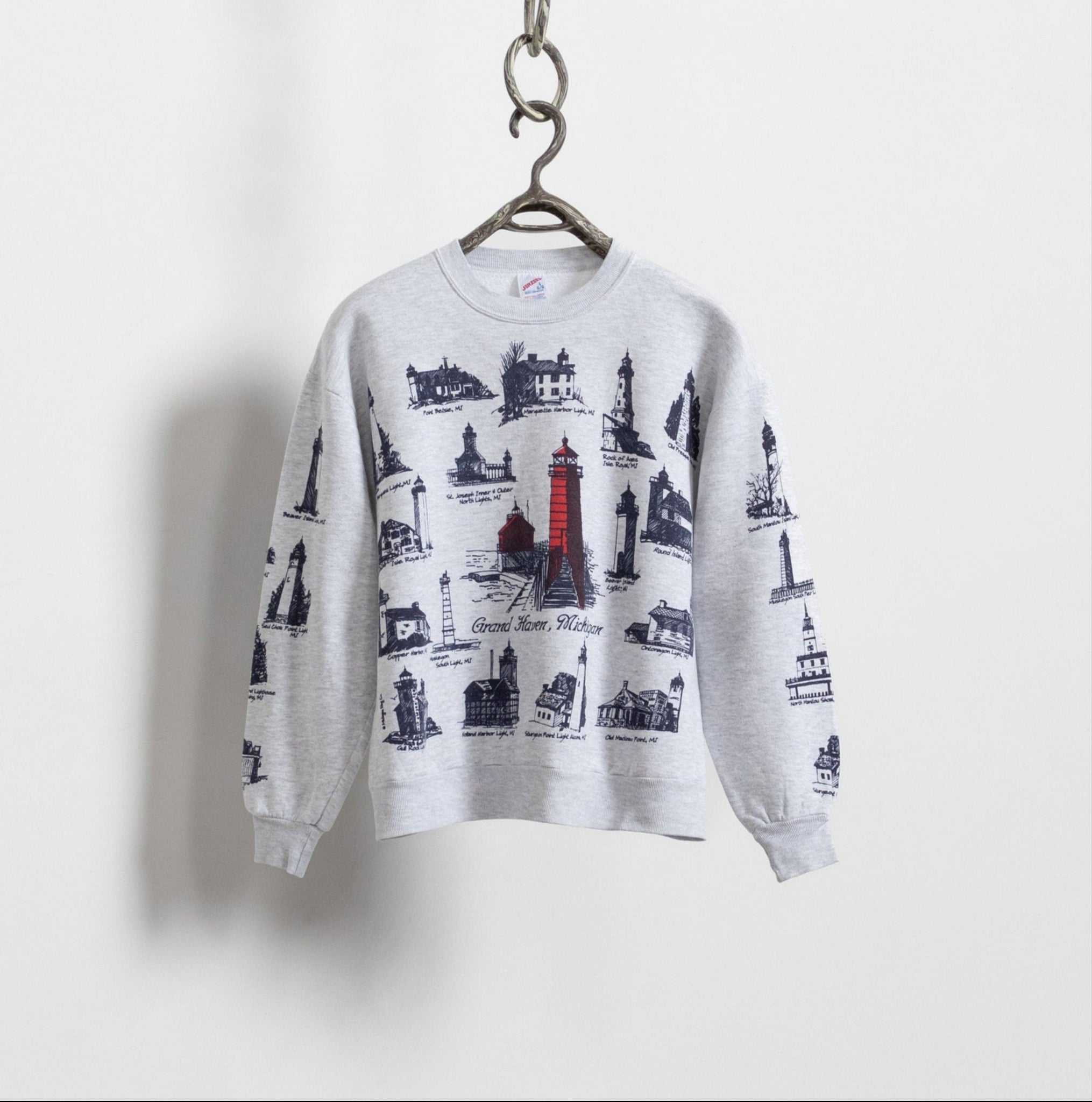 A vintage graphic sweatshirt with an allover lighthouse print, displayed on a white background.