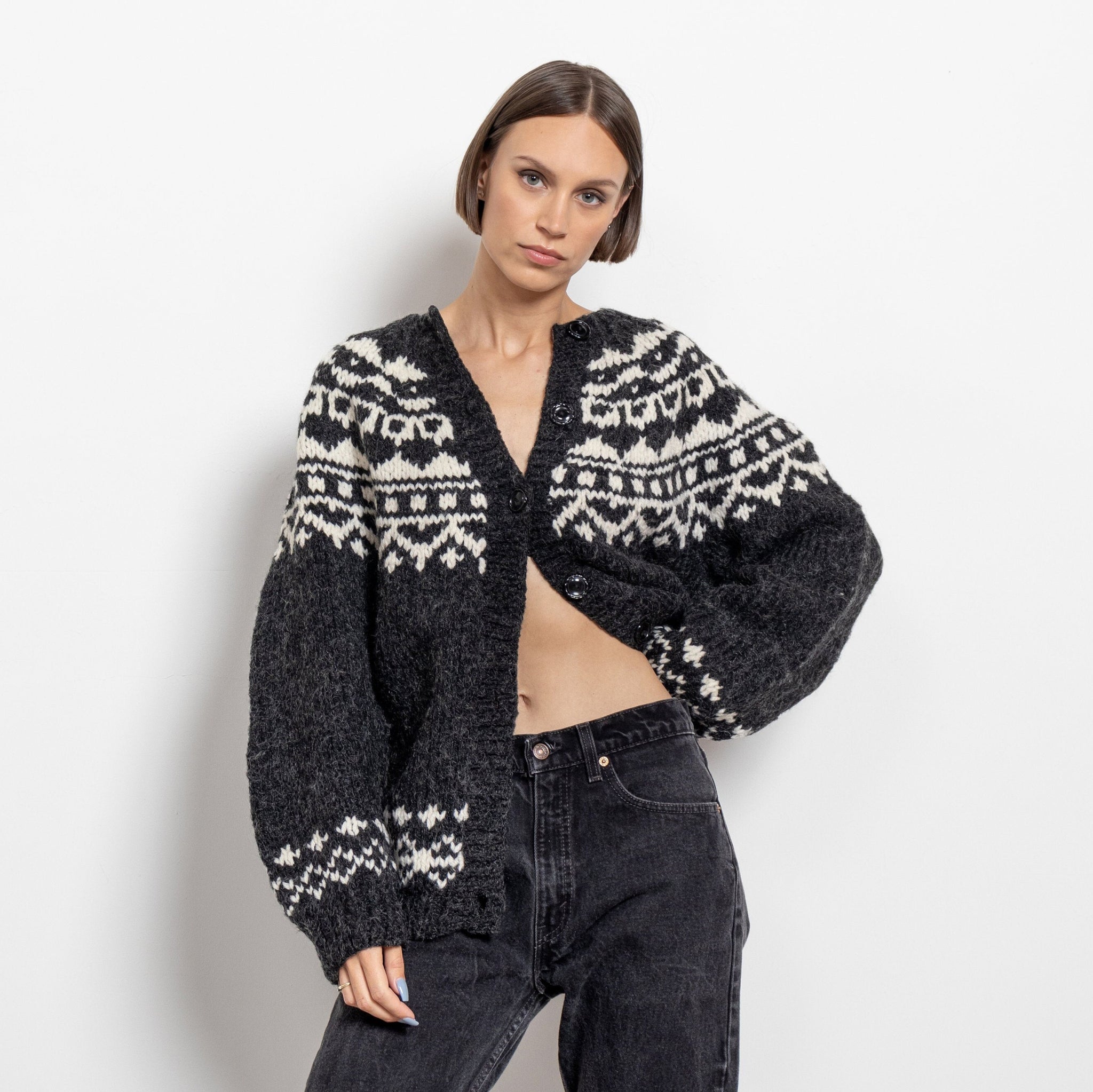A woman modeling a vintage wool traditional fair isle knit cardigan in black and white.