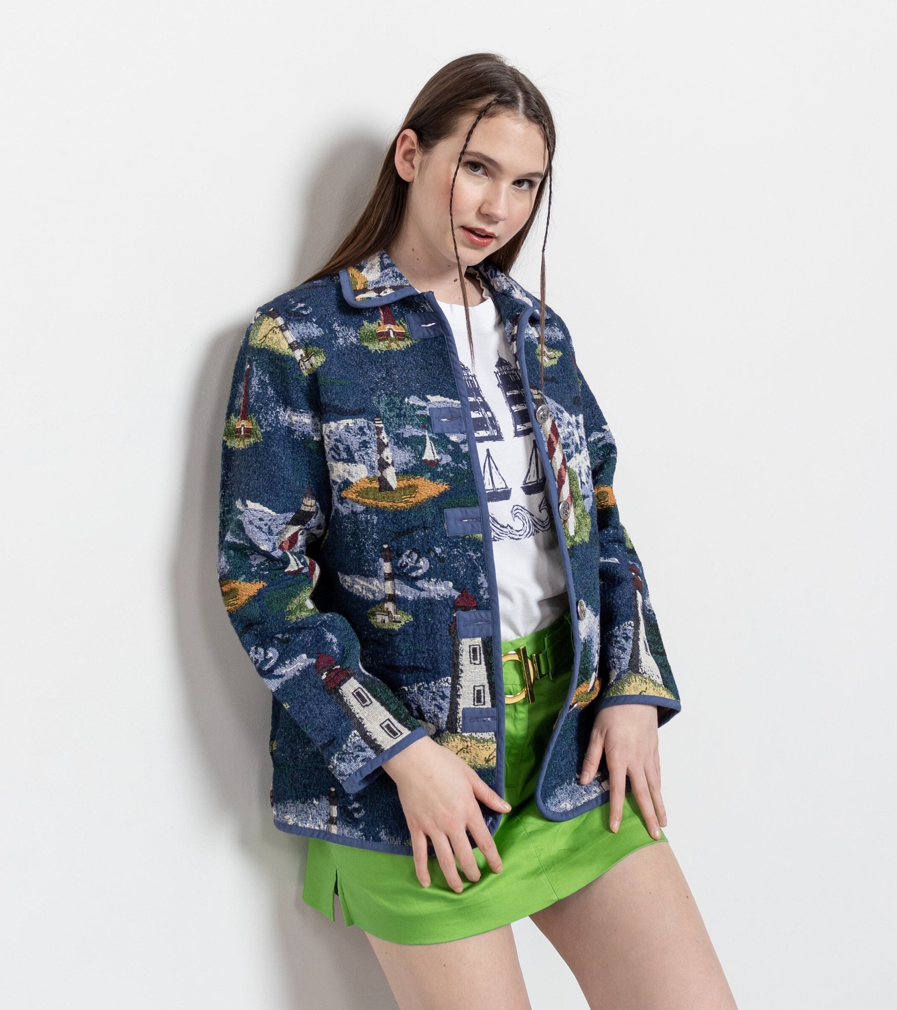 Woman wearing a colorful jacket and green skirt on a white background