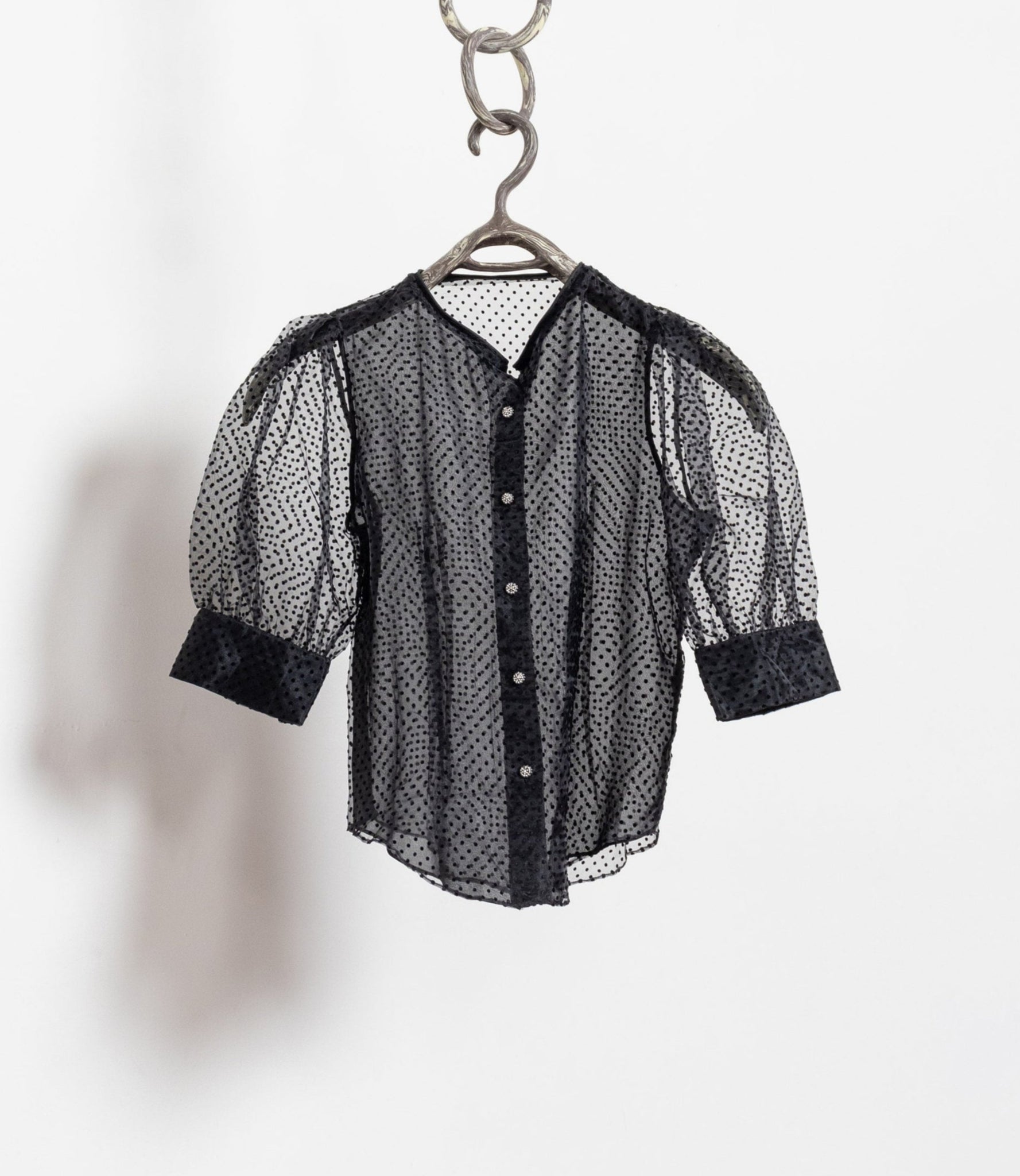 Black and white checkered shirt on a hanger against a white background
