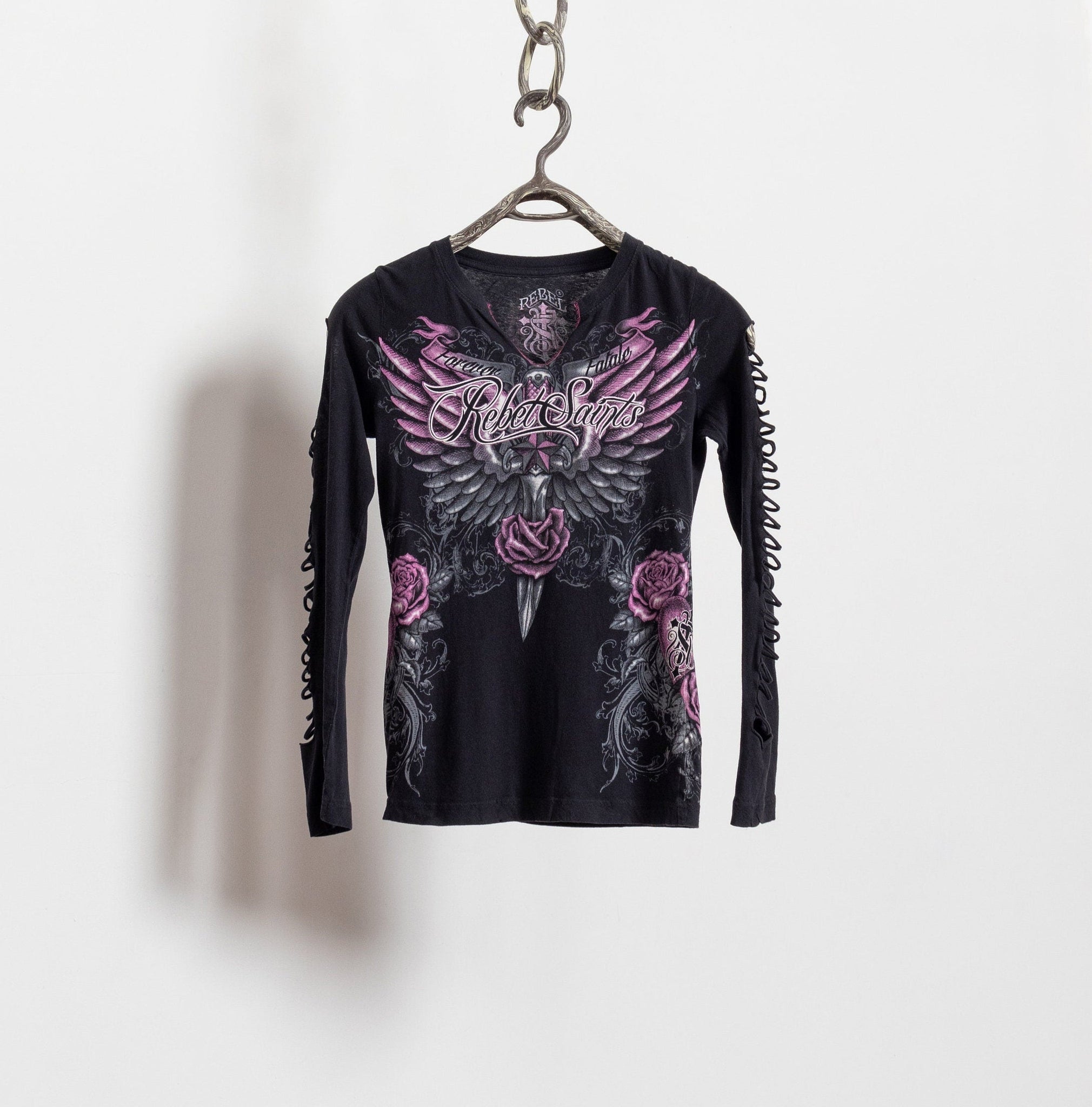 Black long-sleeve shirt with pink floral and wing design on a hanger against a white background