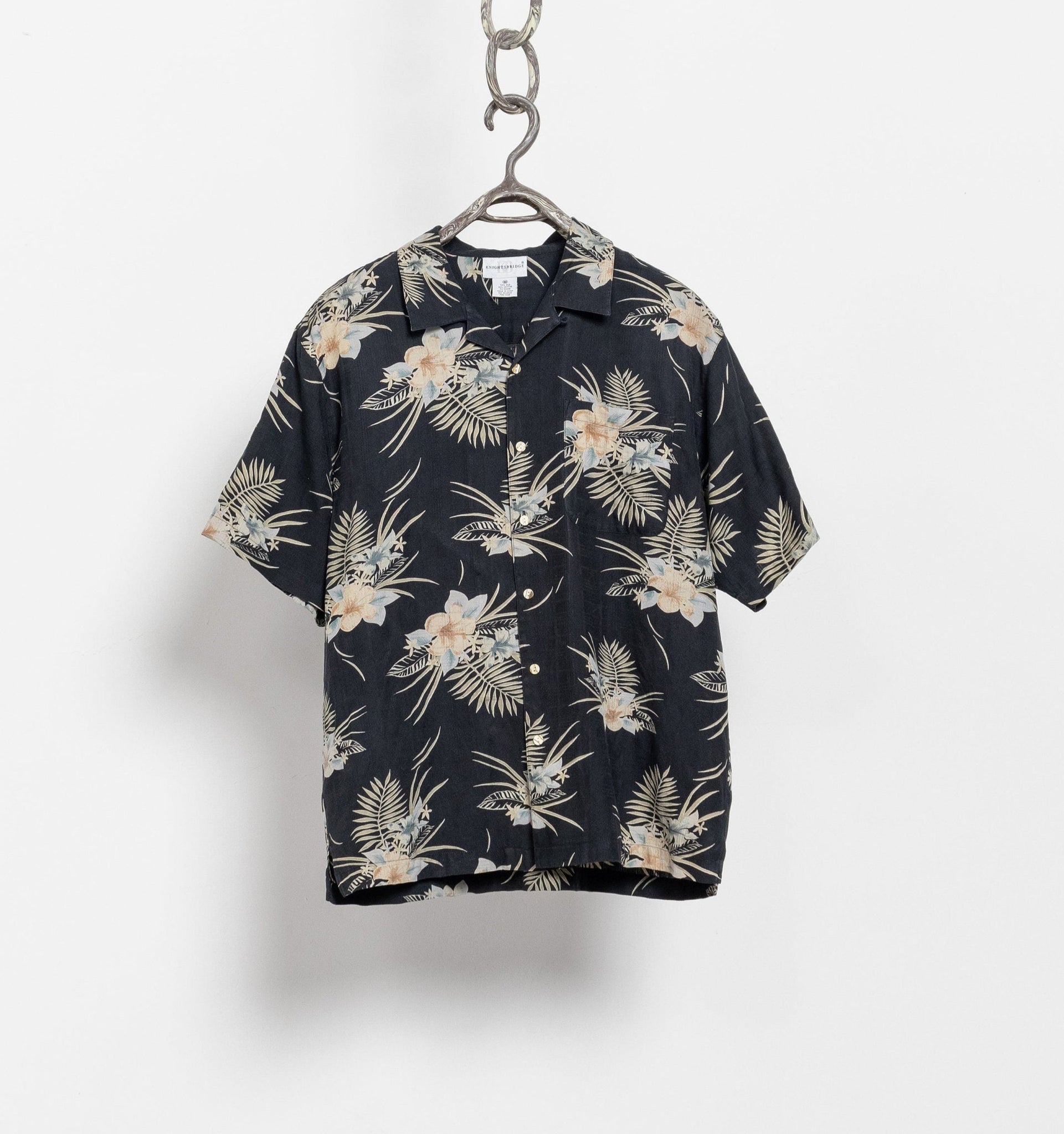 Floral patterned shirt on a hanger against a white background