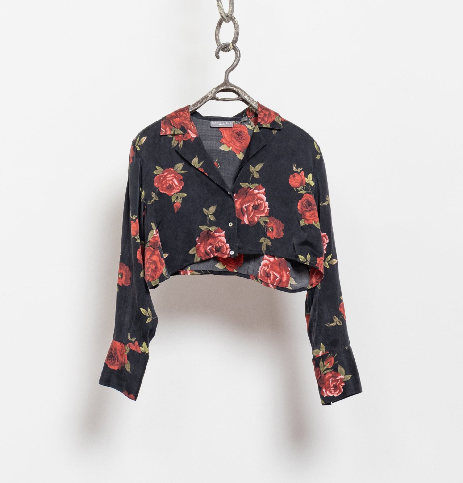 Floral-patterned jacket on a hanger against a white background