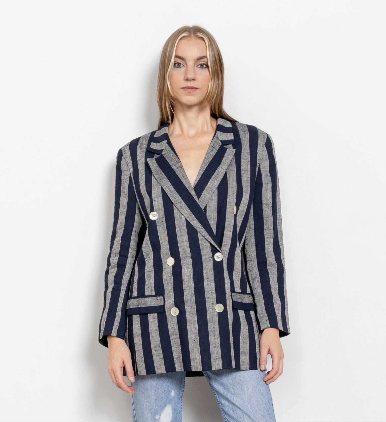 Person wearing a striped blazer and jeans on a white background