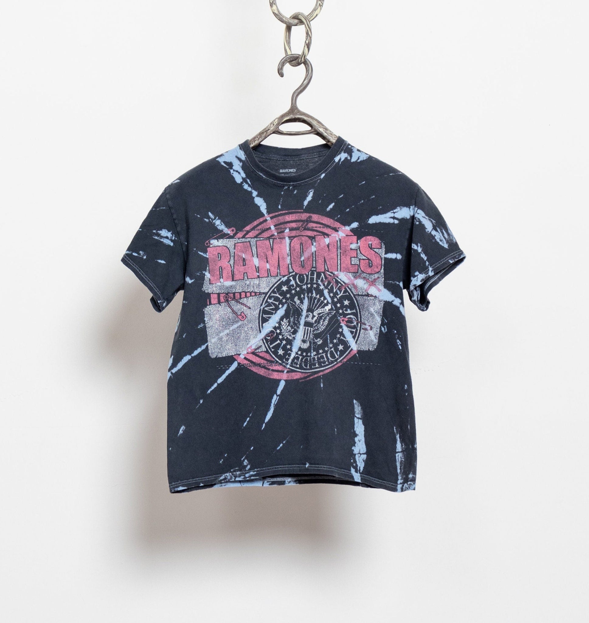 A small fit, light-medium weight, blue and red tie-dye t-shirt with 'The Ramones' graphic on the front, displayed on a hanger against a white background.