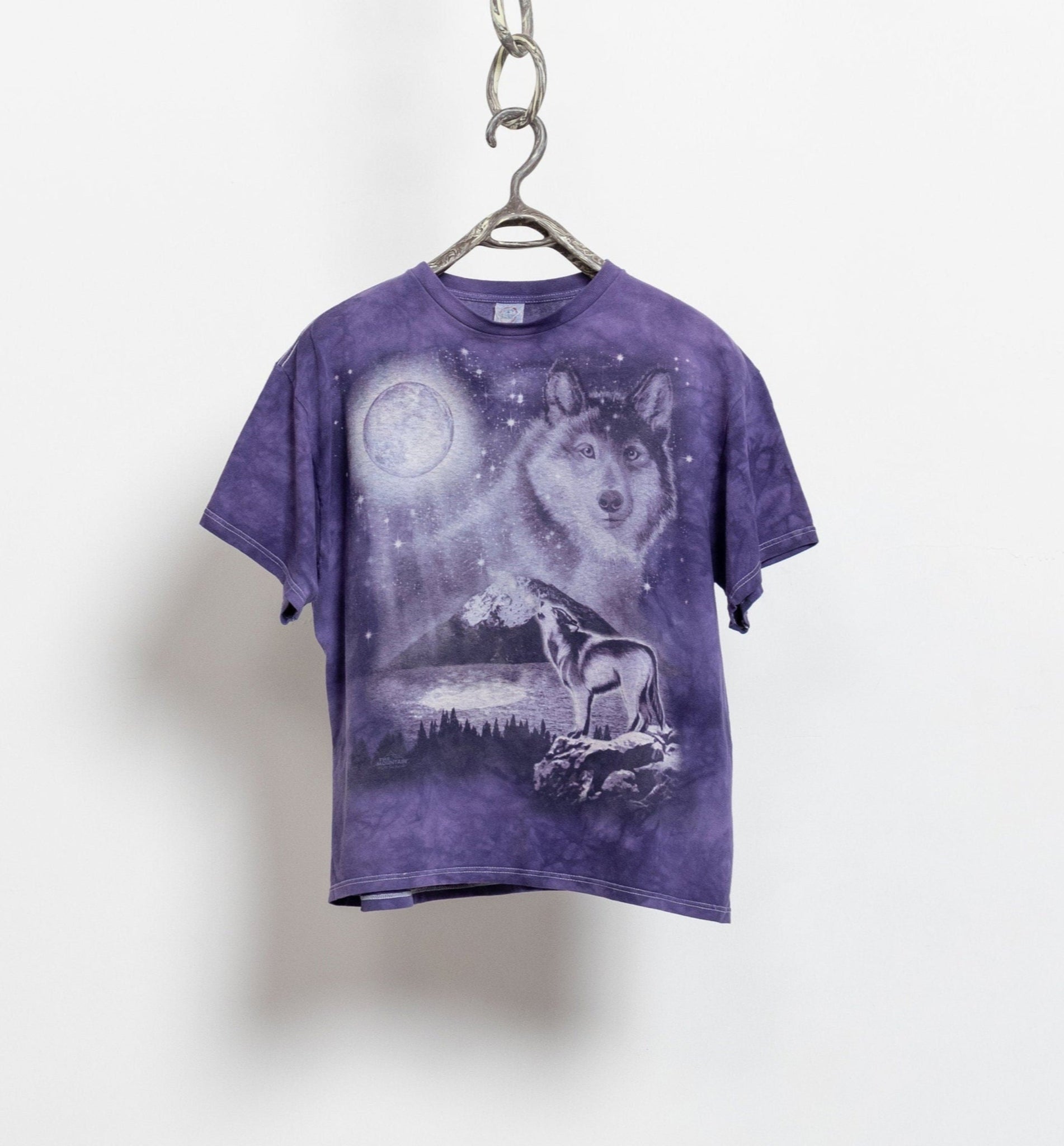 A purple tie-dye graphic t-shirt with a moon and wolf design, displayed on a hanger against a white background.