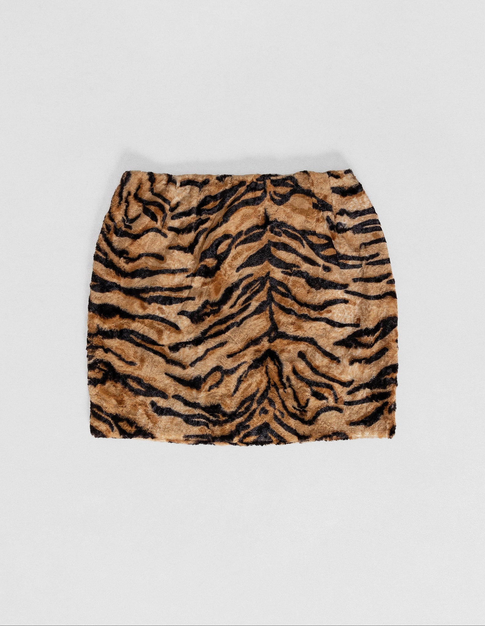 A vintage 90's leopard print faux fur mini skirt on a white background.