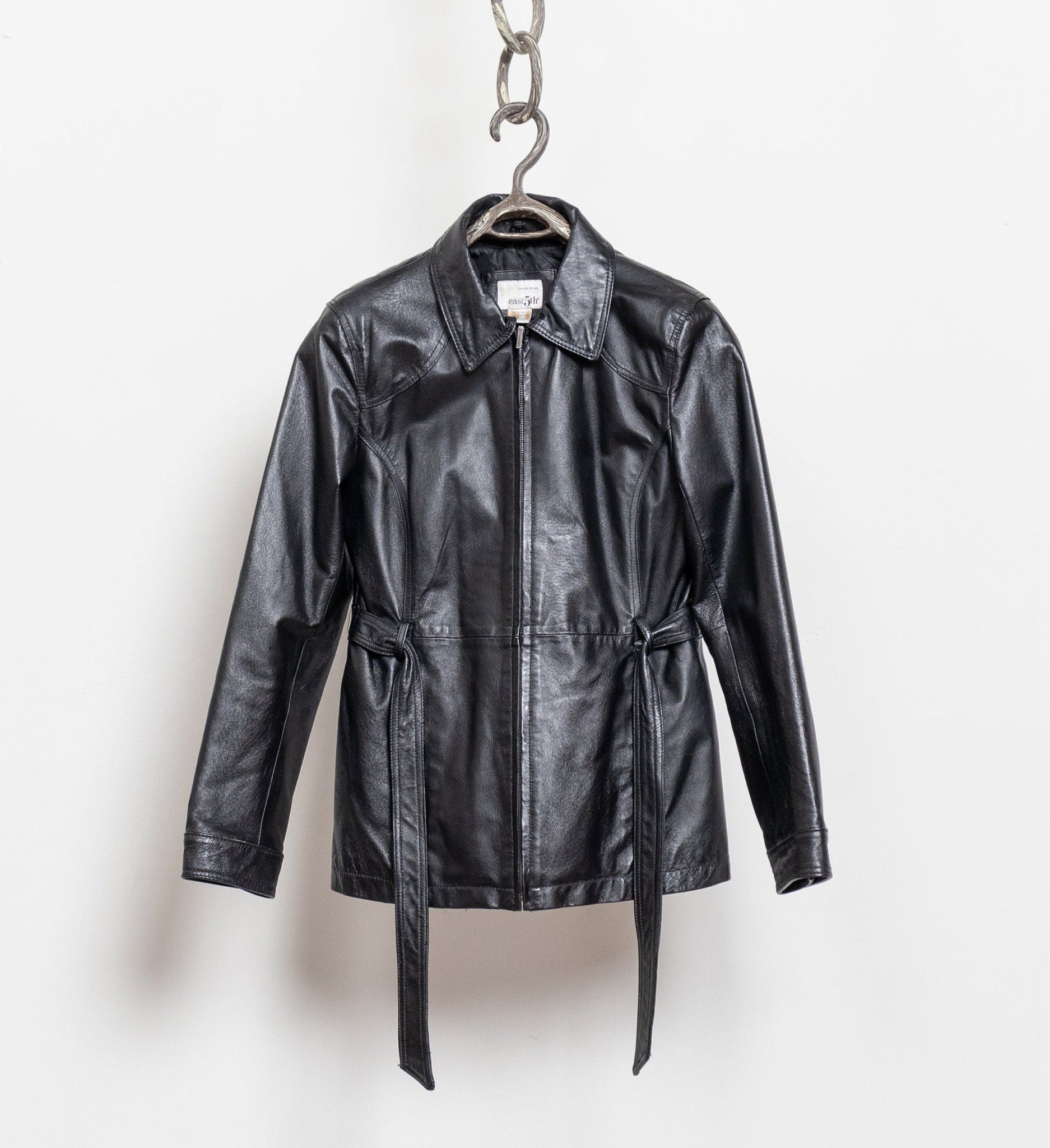 Black leather jacket hanging on a white background