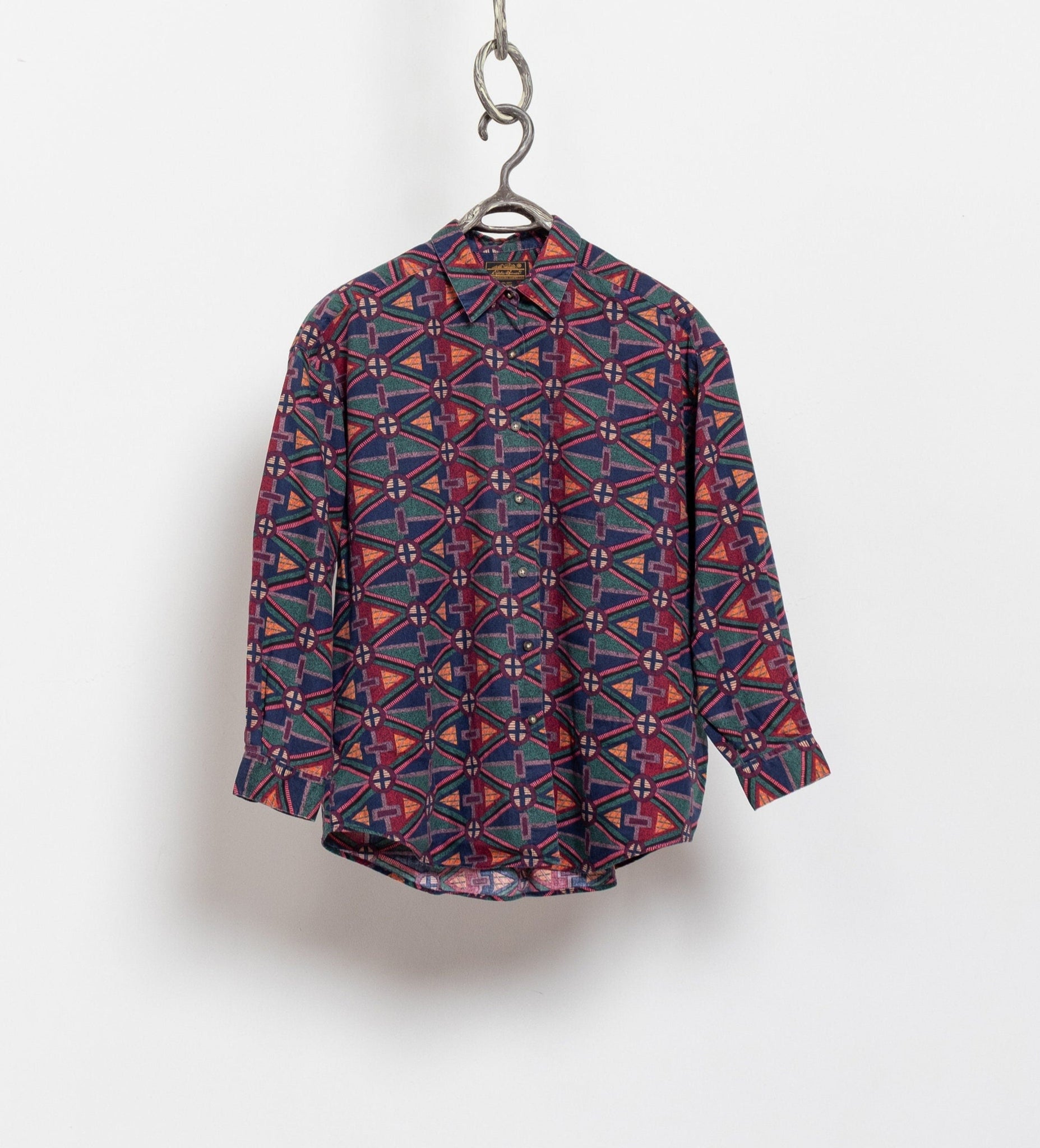 Patterned shirt on a hanger against a white background