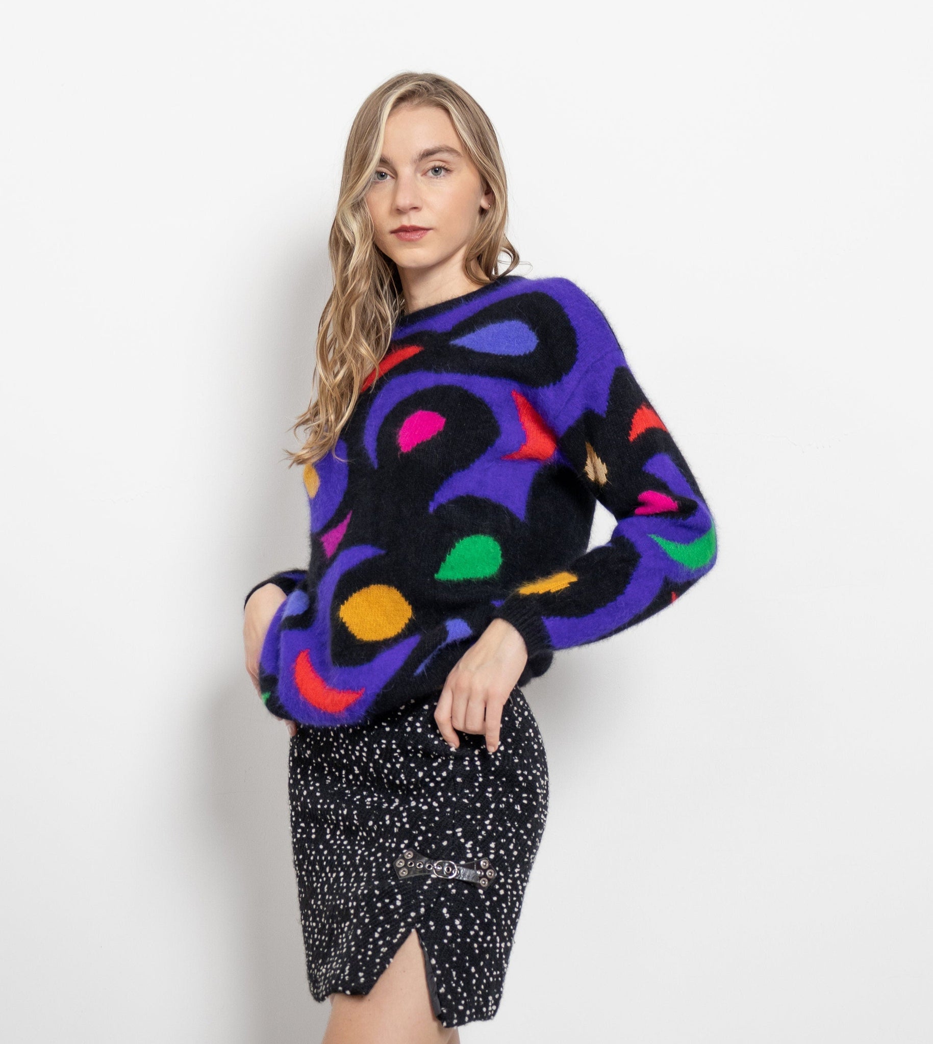 Woman wearing a colorful sweater with abstract patterns on a white background