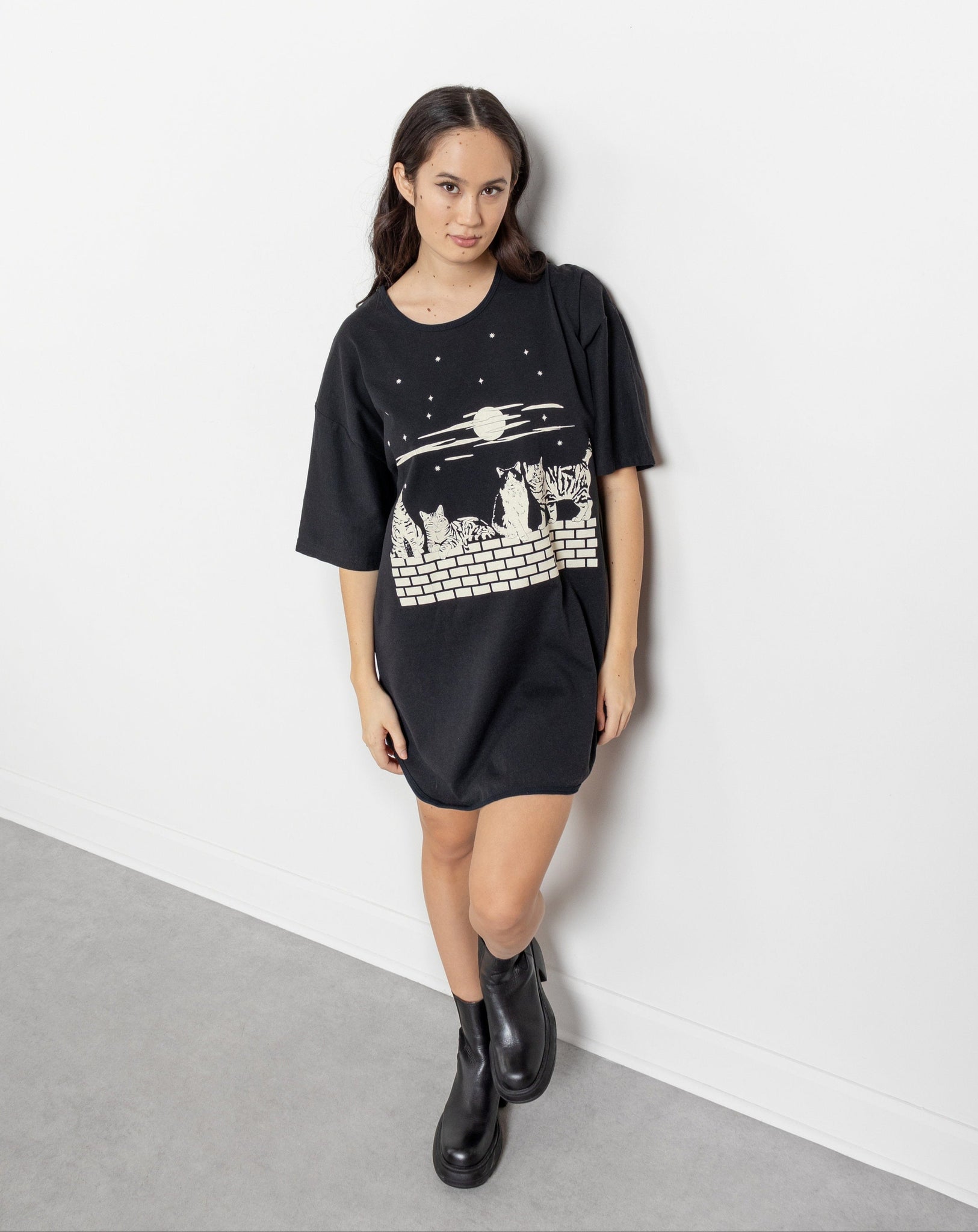 Woman wearing a black t-shirt with a graphic design against a white background