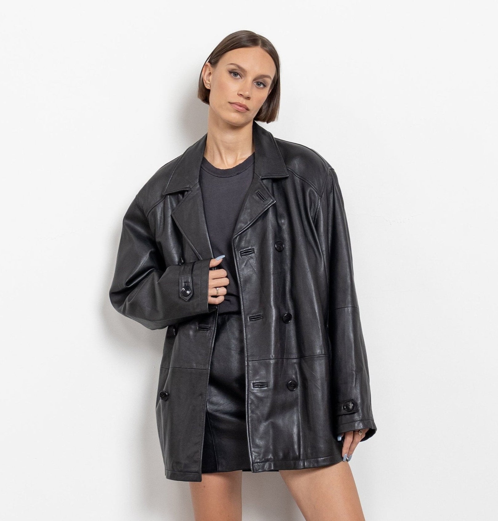 Person wearing a black leather jacket against a white background