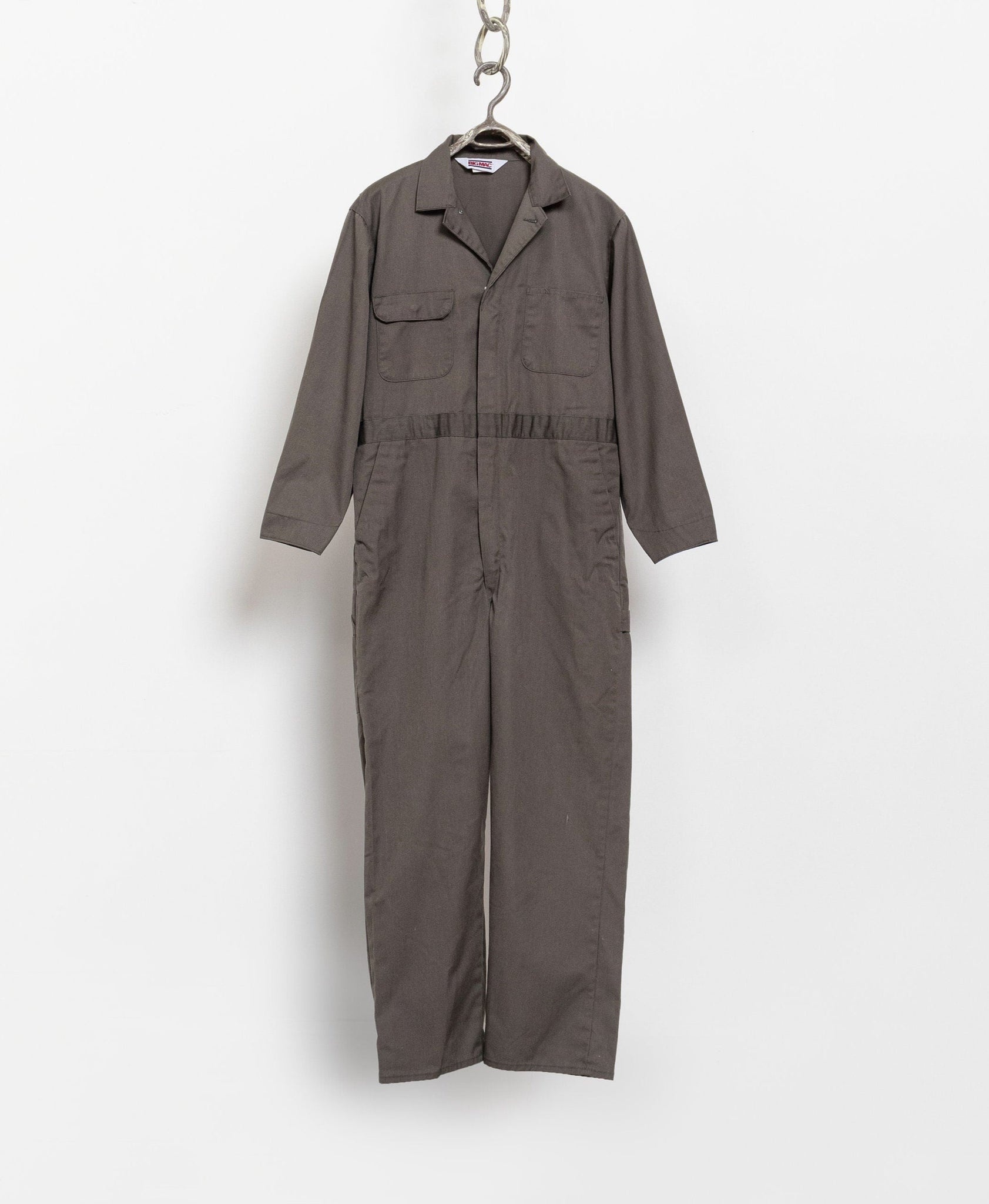 A gray vintage 80's cotton blend one-piece short sleeve boiler suit hanging against a white background.