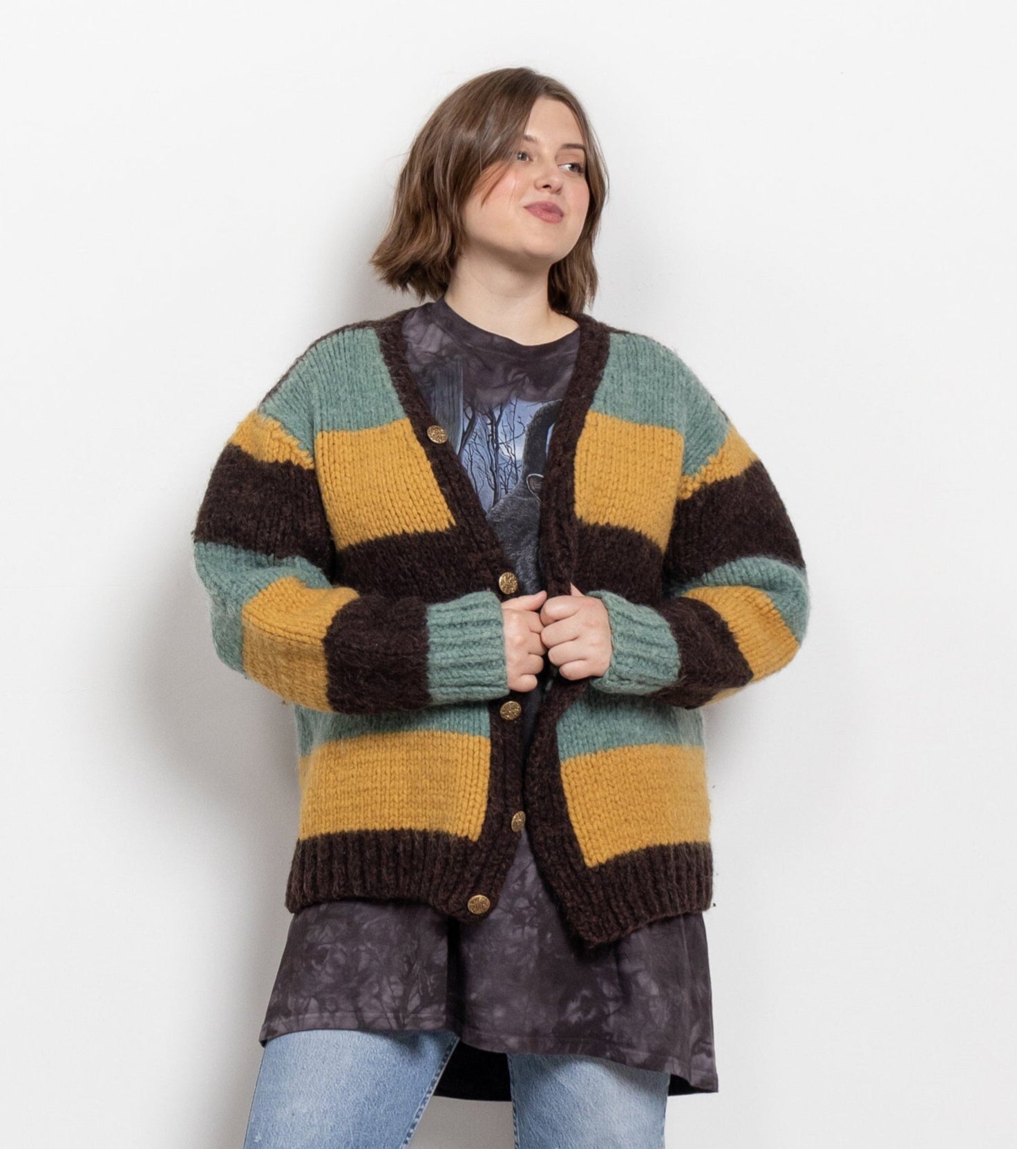 Person wearing a colorful striped cardigan on a plain background