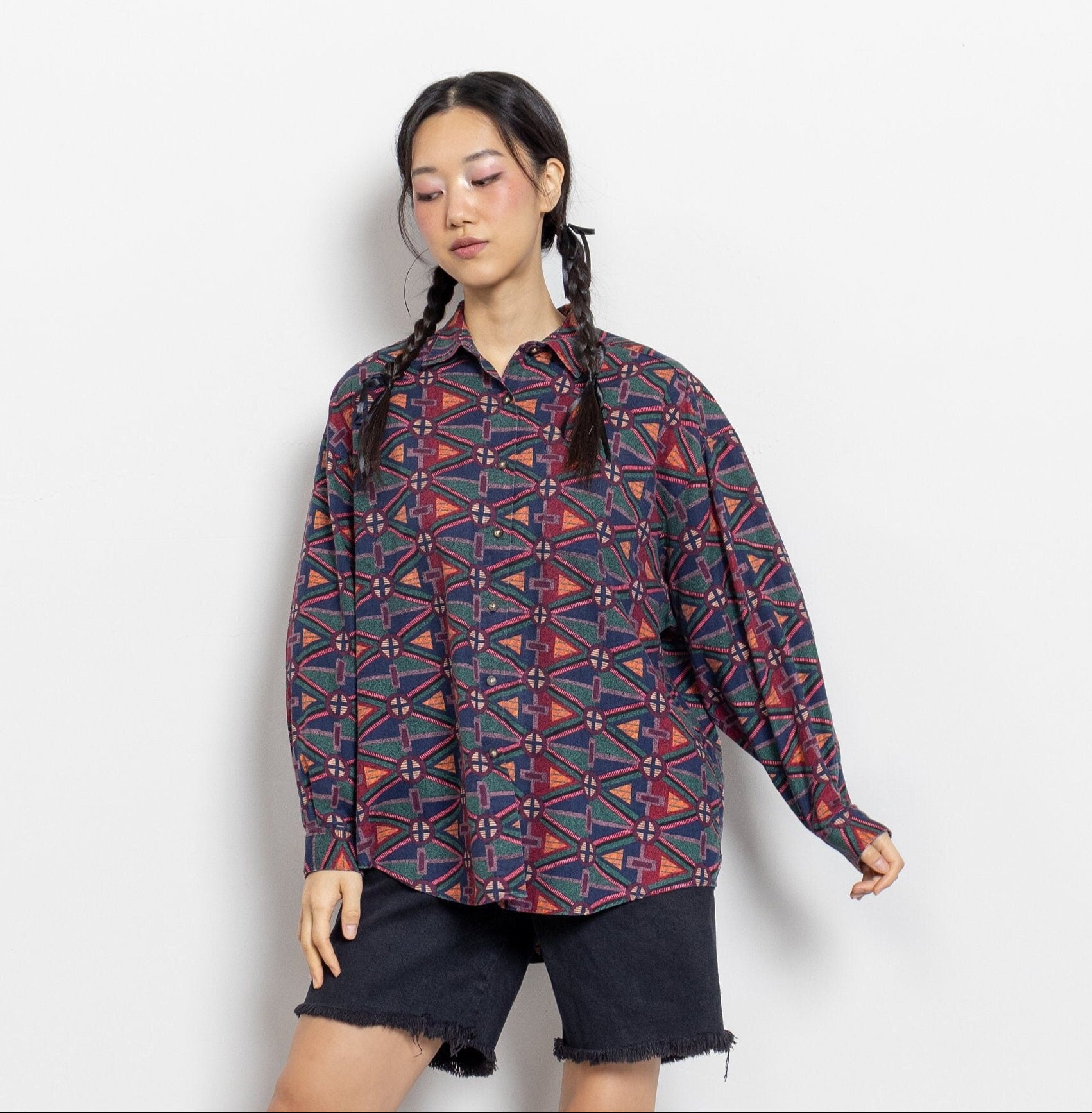 A person modeling a vintage 90's multicolored abstract print button-up oxford shirt with long sleeves and a collar.