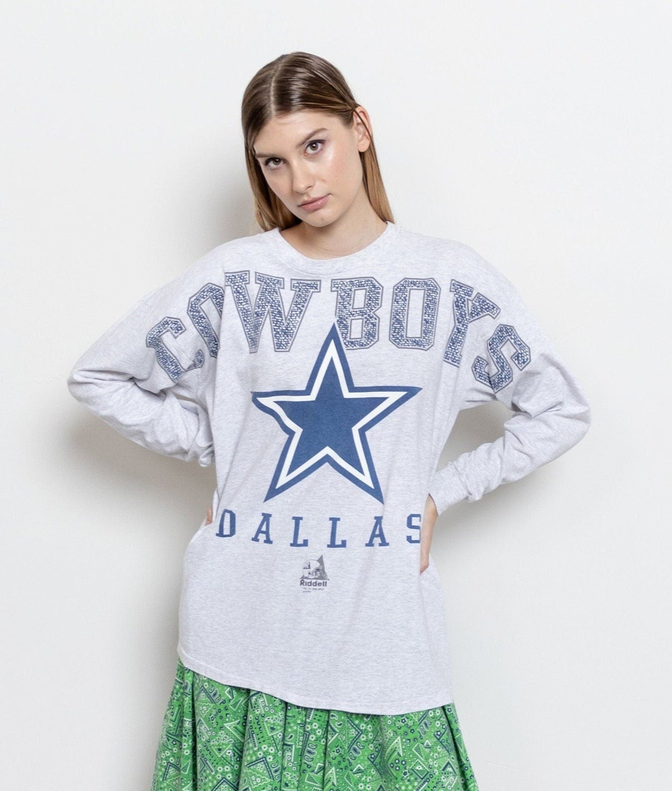Woman wearing a Dallas Cowboys sweatshirt with a blue star on a white background