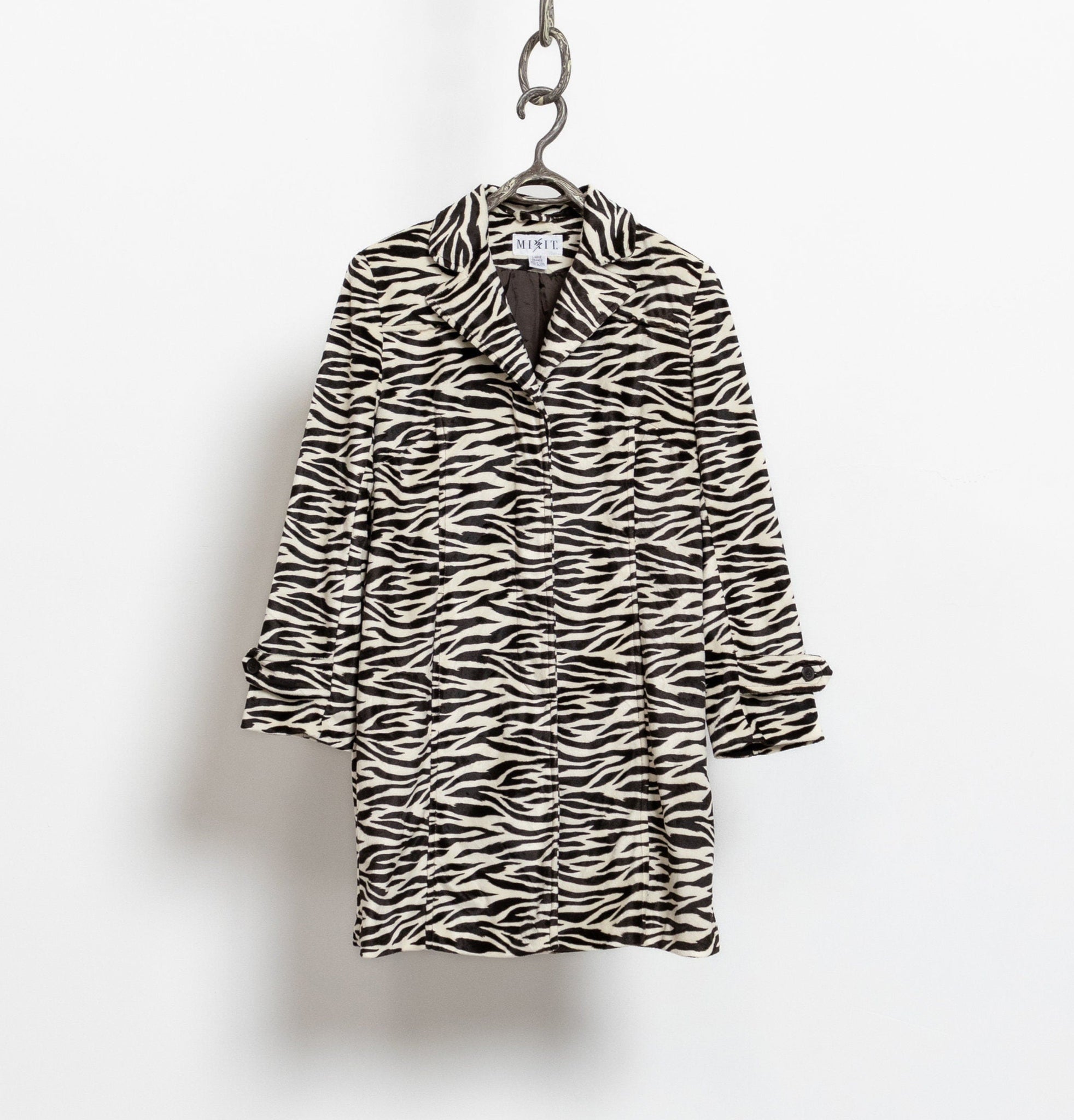 Zebra patterned coat on a hanger against a white background