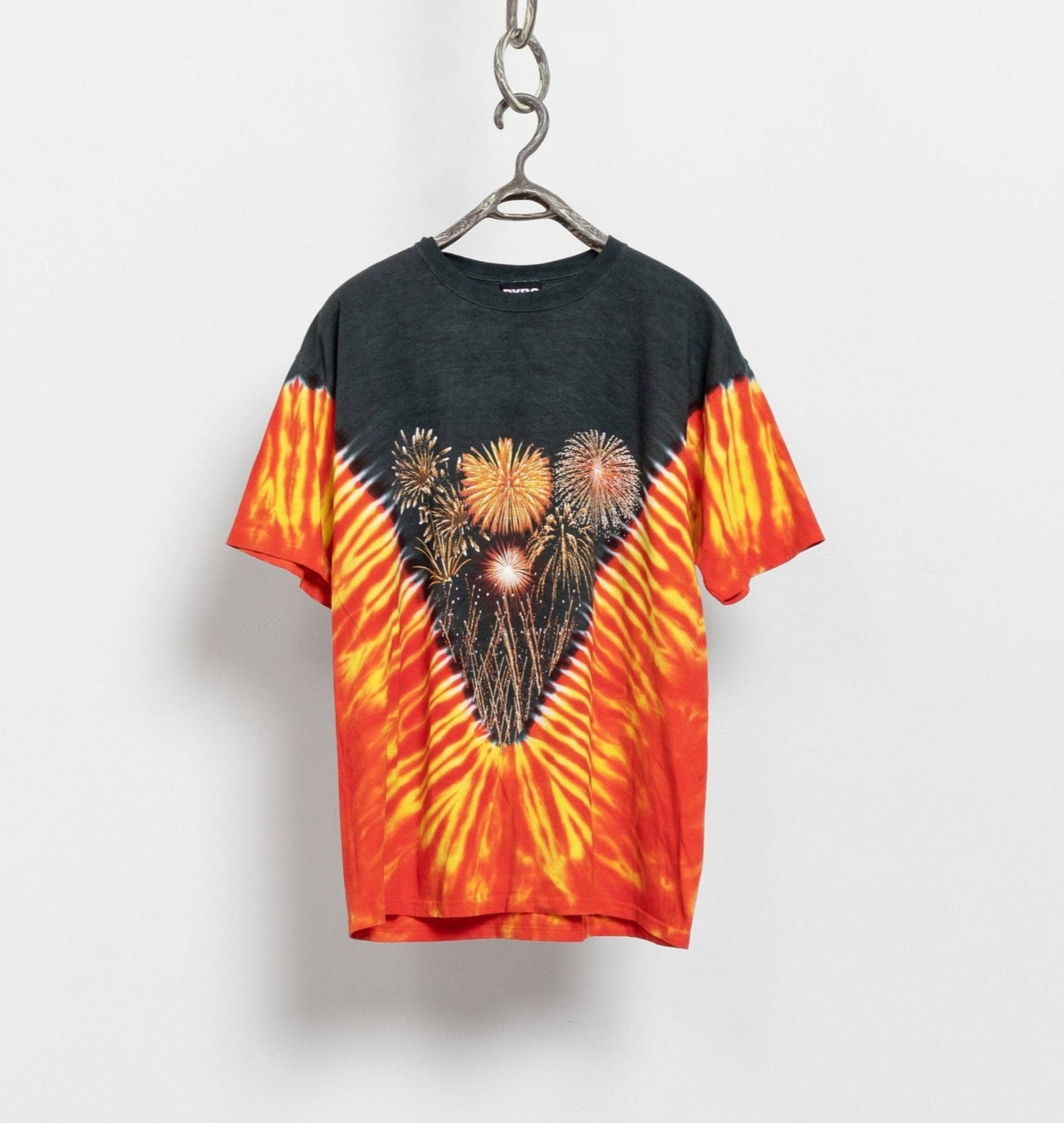 Tie-dye t-shirt with heart design and fireworks on a hanger against a white background
