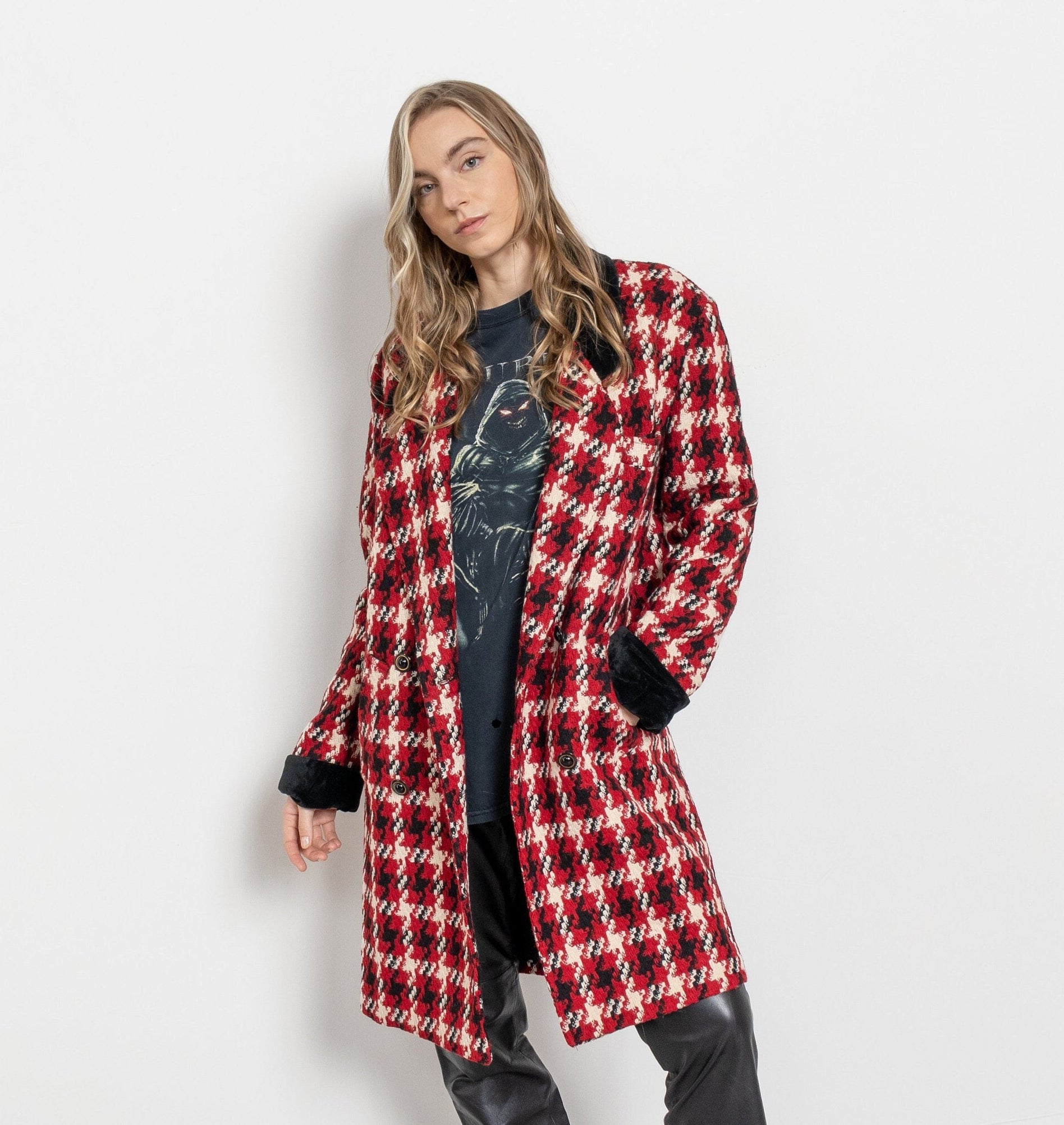 Woman wearing a red and black checkered coat against a white background