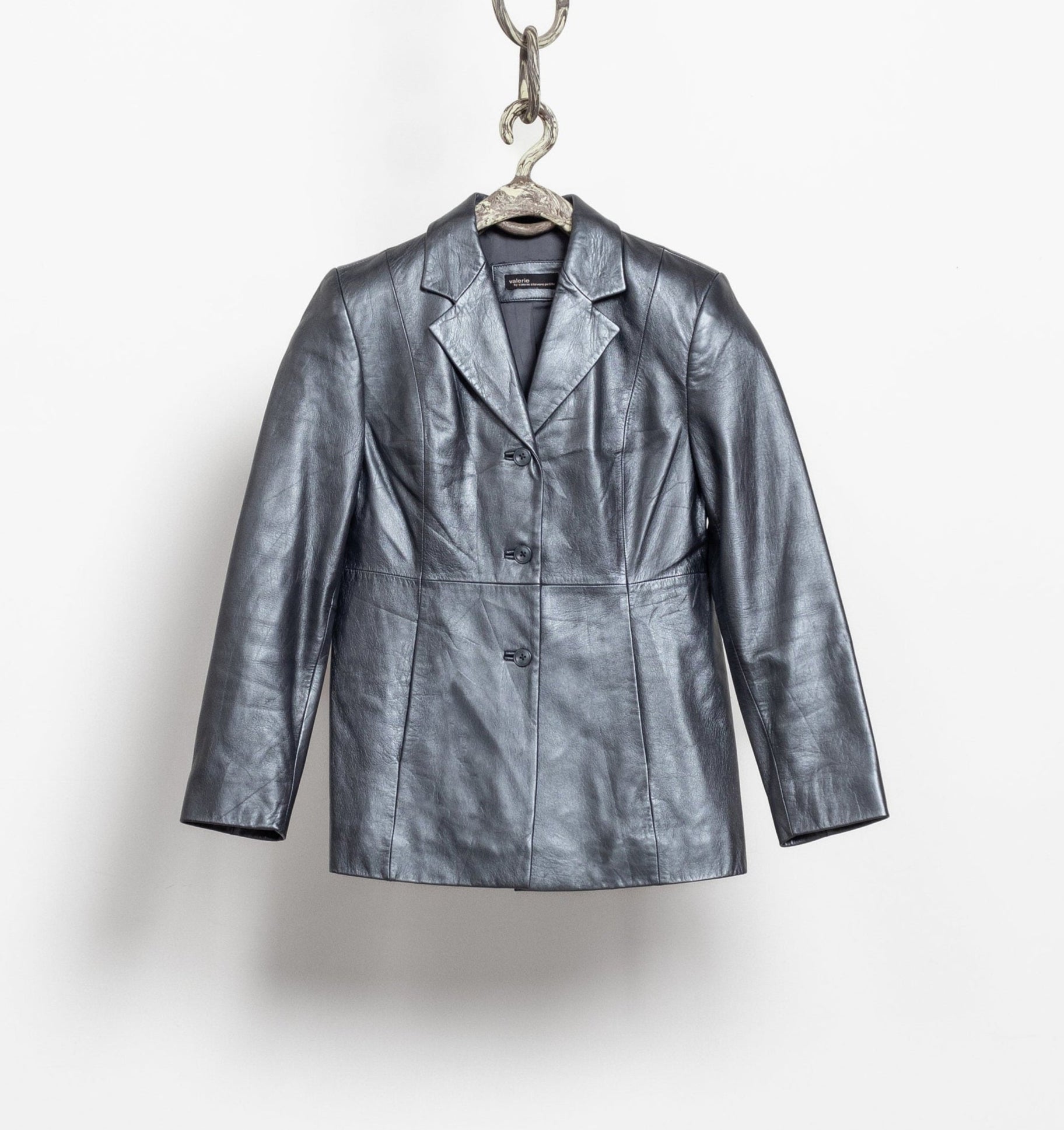 Silver metallic jacket on a hanger against a white background