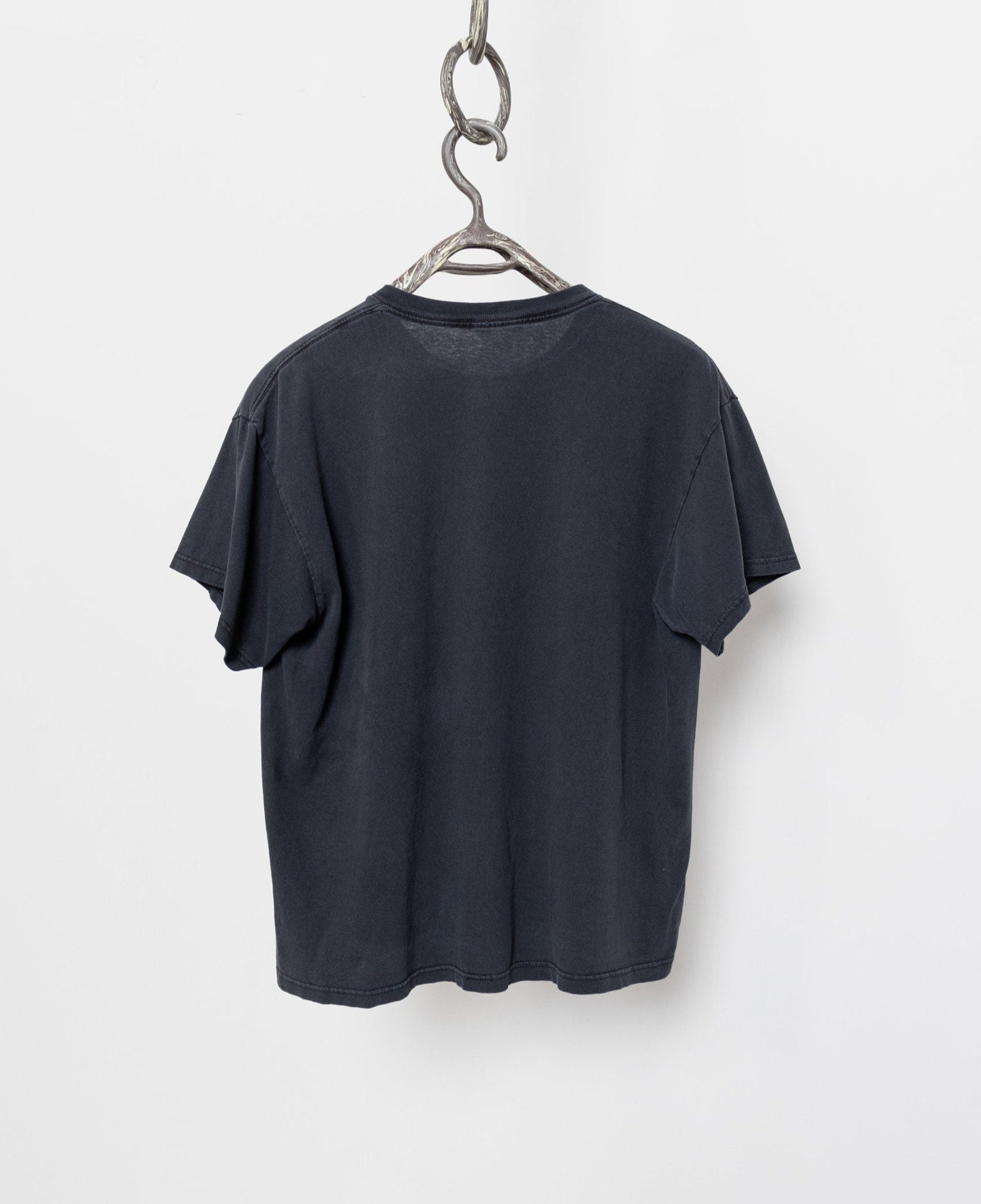 Black t-shirt hanging on a hanger against a white background