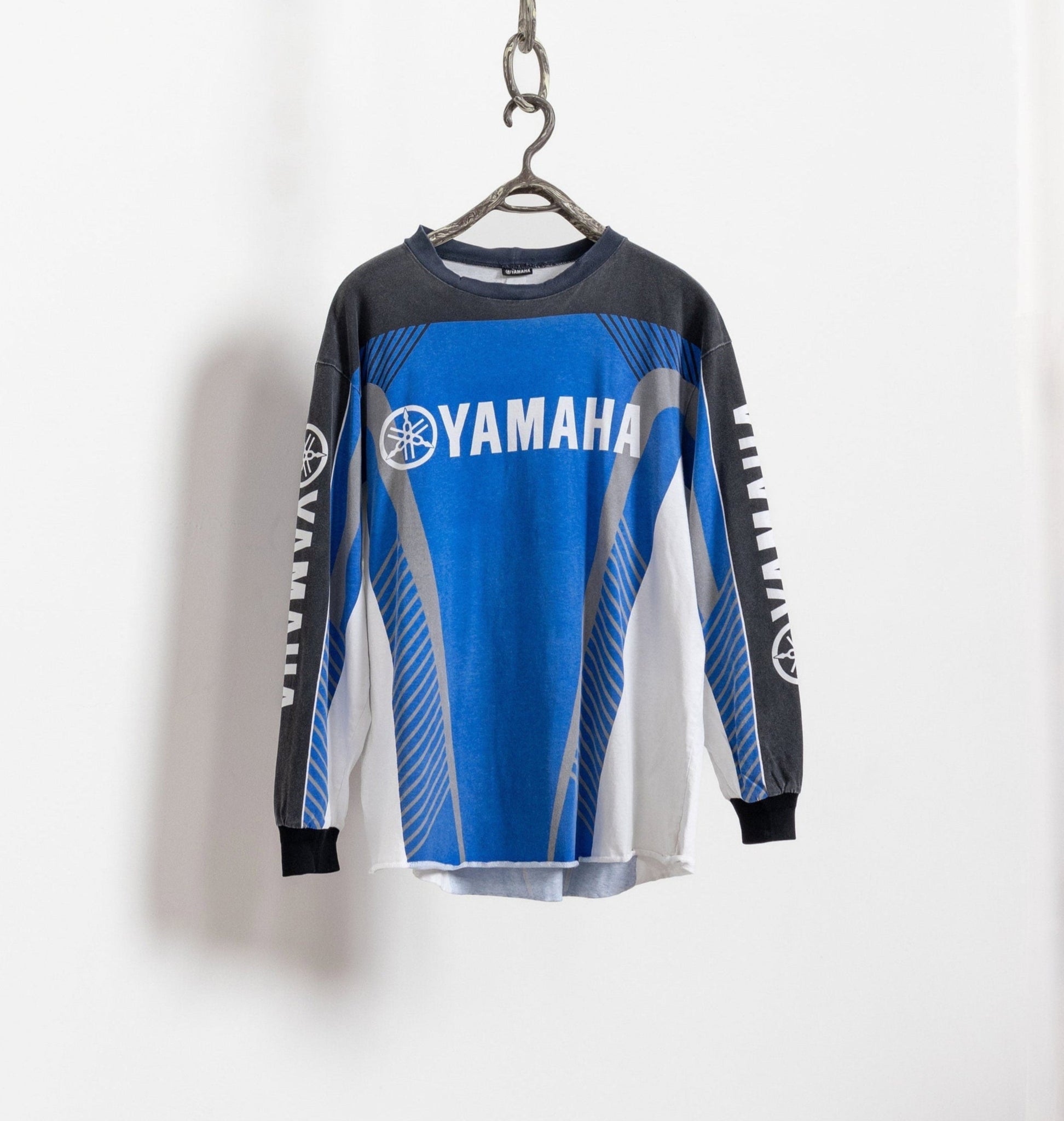 Blue and gray Yamaha long-sleeve shirt on a hanger against a white background