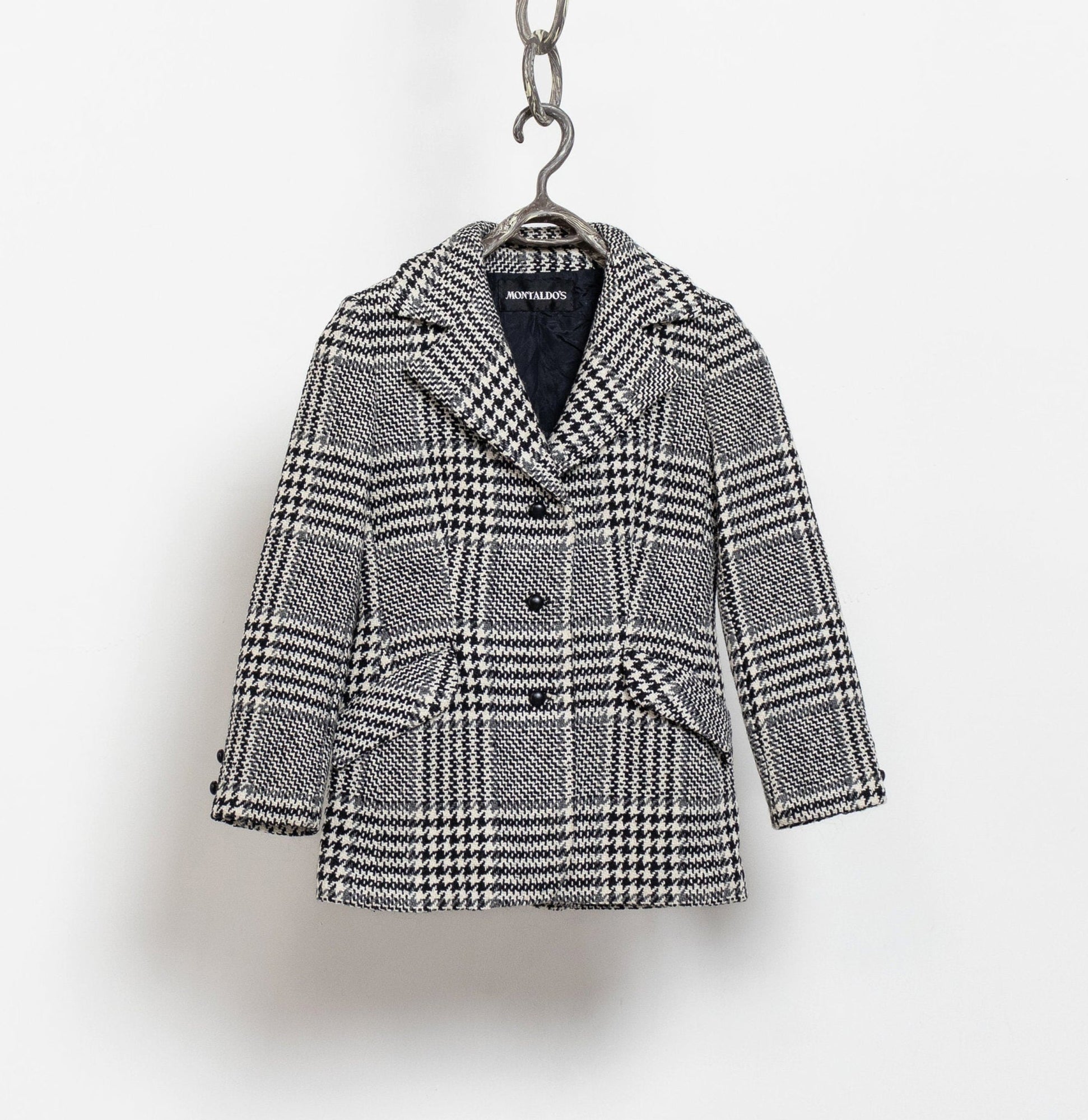 Houndstooth pattern coat on a hanger against a white background