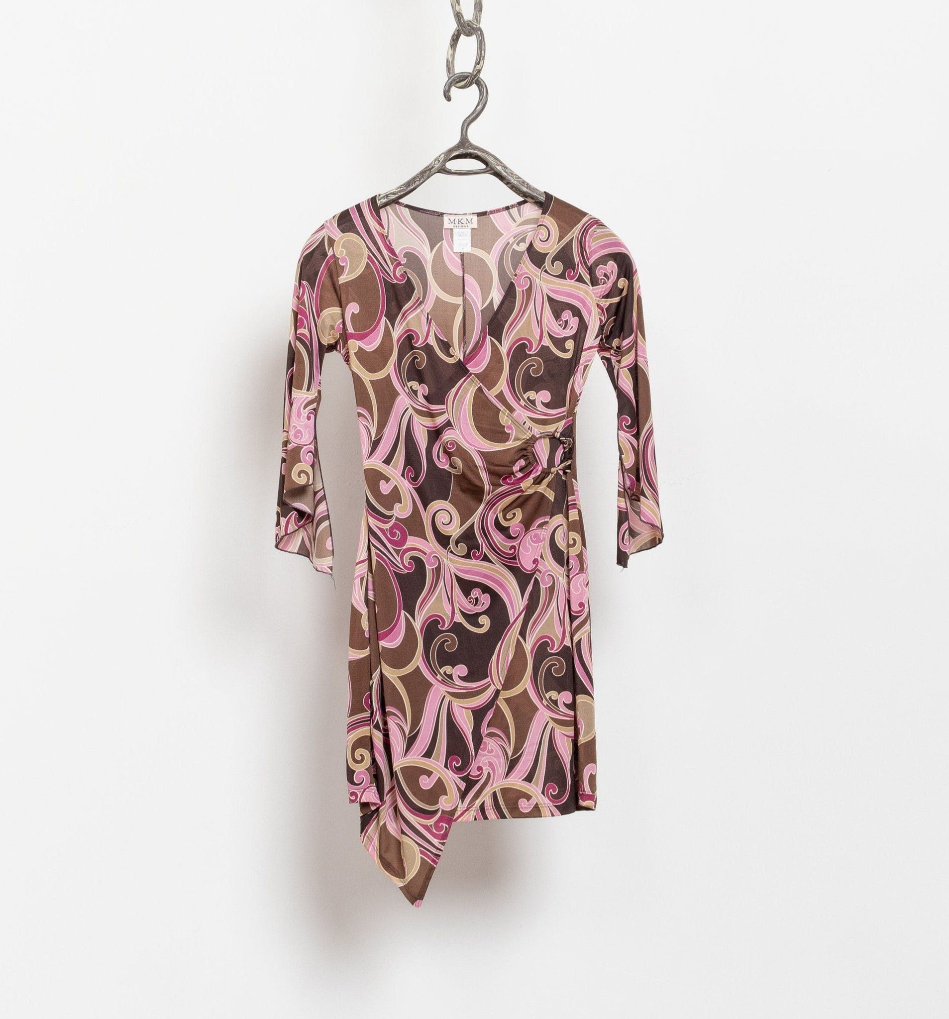 Vintage pink and brown paisley wrap dress with bell sleeves and an asymmetrical hemline, displayed on a hanger against a white background.