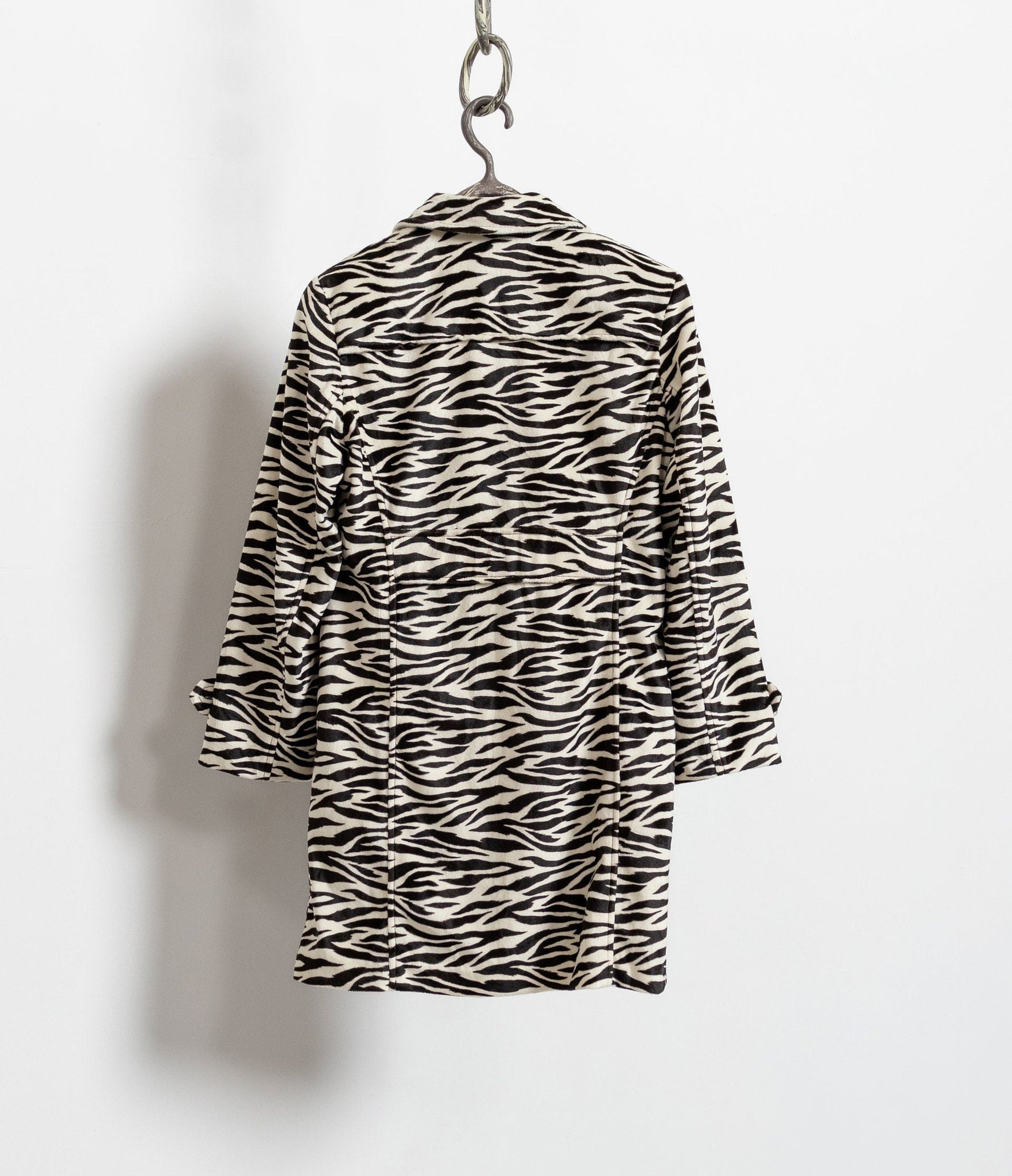 Zebra print dress on a hanger against a white background
